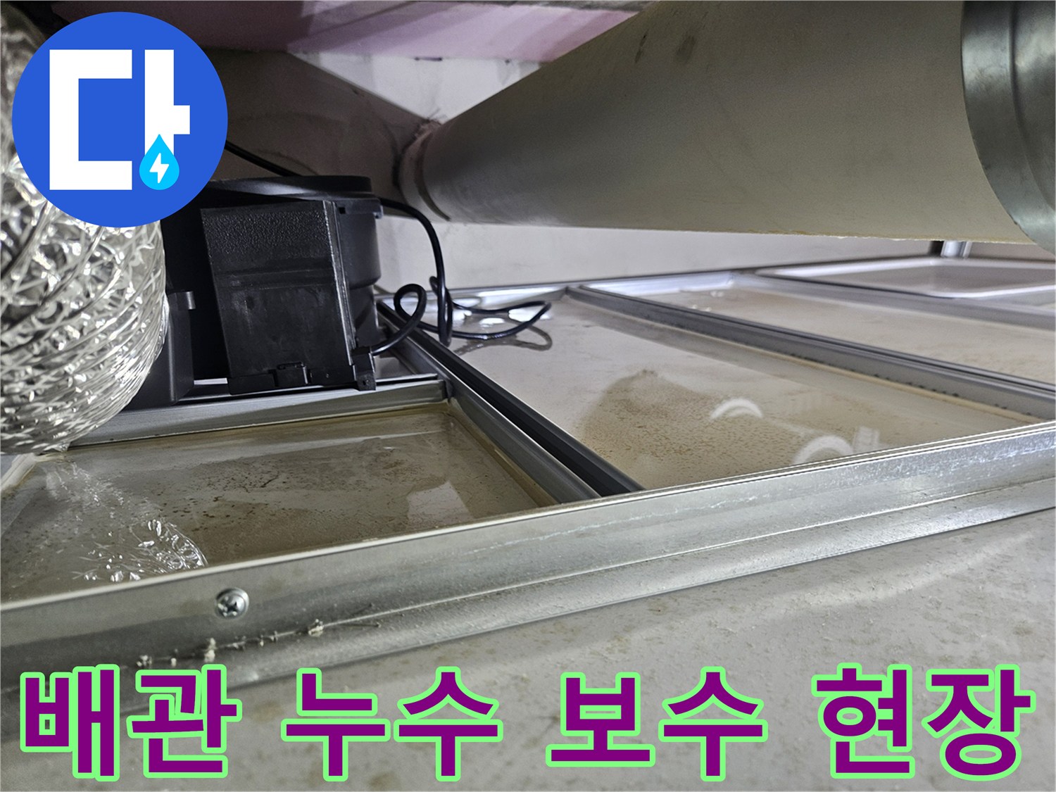 천장 속 배관에서 누수가 발생하여-물이 고여있는 현장을 보여주는 사진으로-배관 교체 및 보수 작업이 필요한 상황