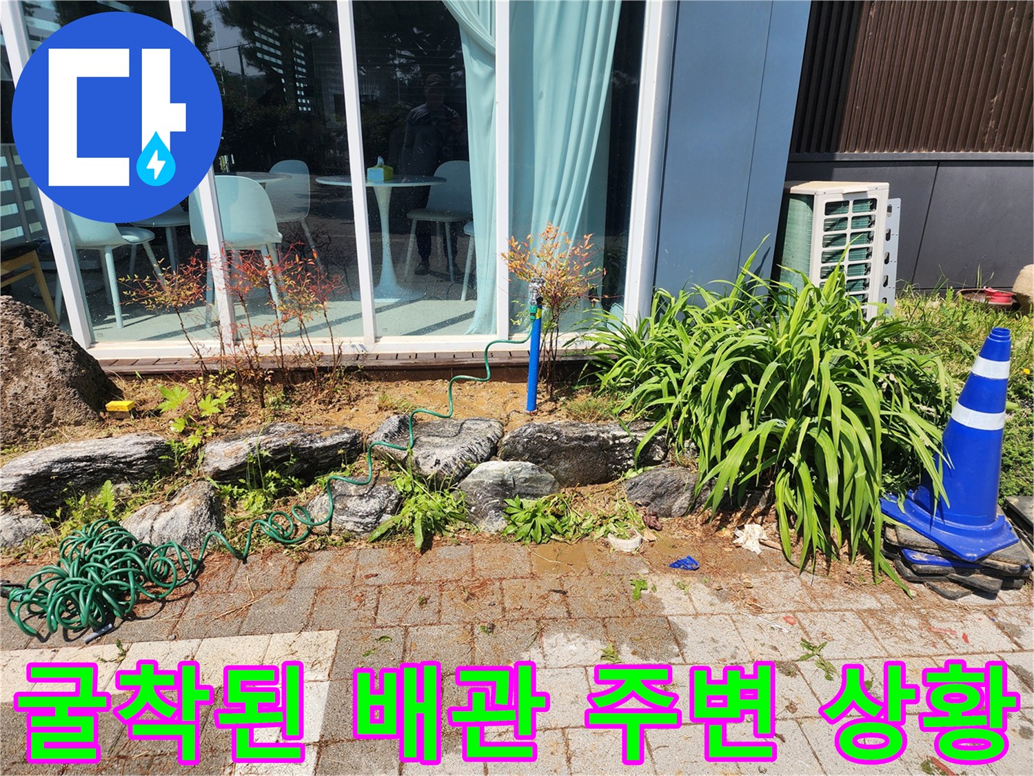외부 수전 하단 흙을 파내어 드러난 배관과 주변 돌들의 모습