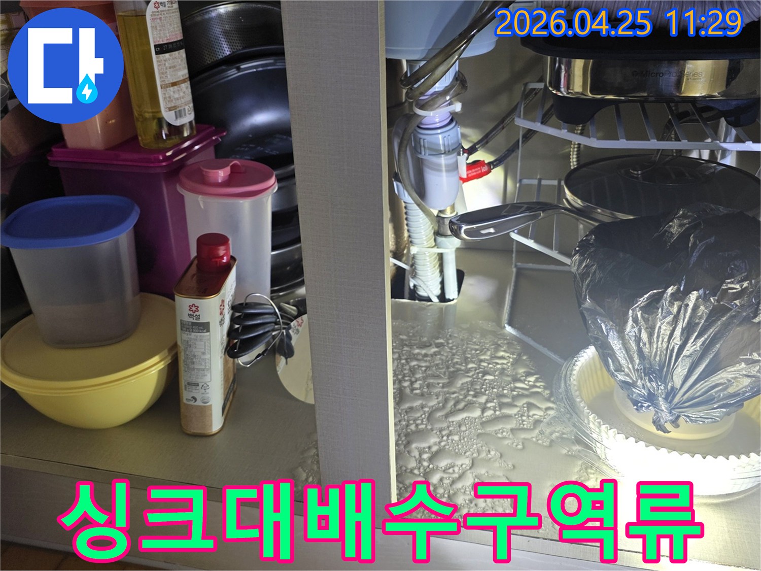 싱크대 배수구에서 물이 역류하여-하부장에 고인-누수 현장을-정밀하게 점검하는 모습입니다