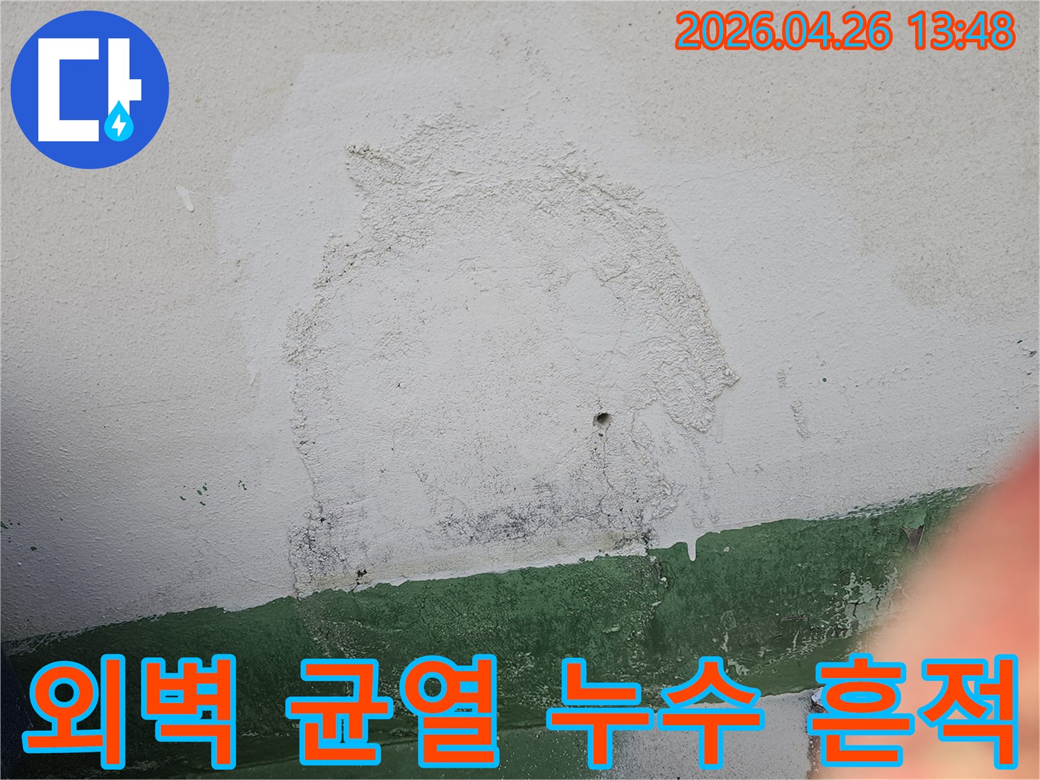 건물 외벽에 발생한 균열을 통해-물이 스며들어-벽면이 오염되고-마감재가 손상된 상황을 나타냅니다.