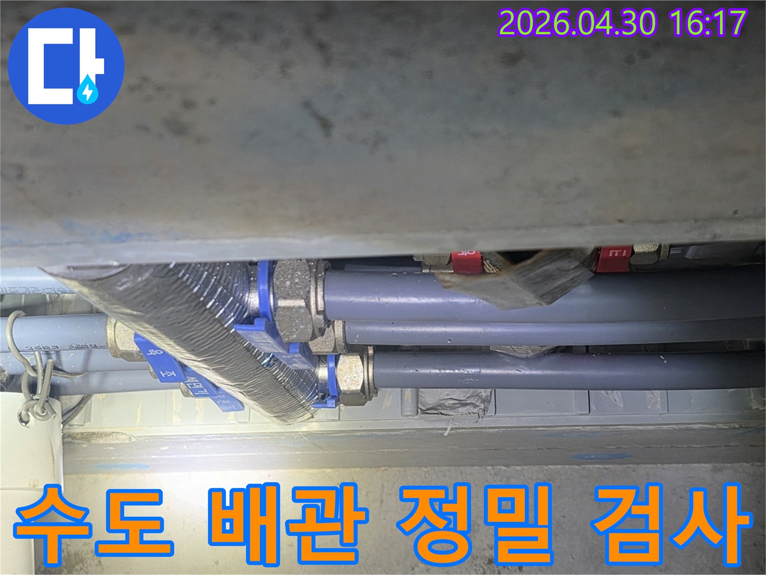 누수 엔지니어가-아파트 수도 배관의-연결 부위를-정밀하게 검사하여-누수 여부를-확인하는 모습