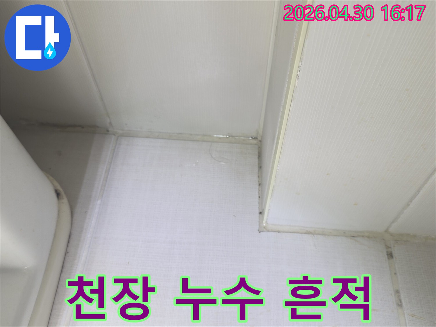 천장과 벽의 경계에서 물이 새어 나와-벽지가 젖어있는 상태를 보여주는-누수 발생 현장의 증거 사진