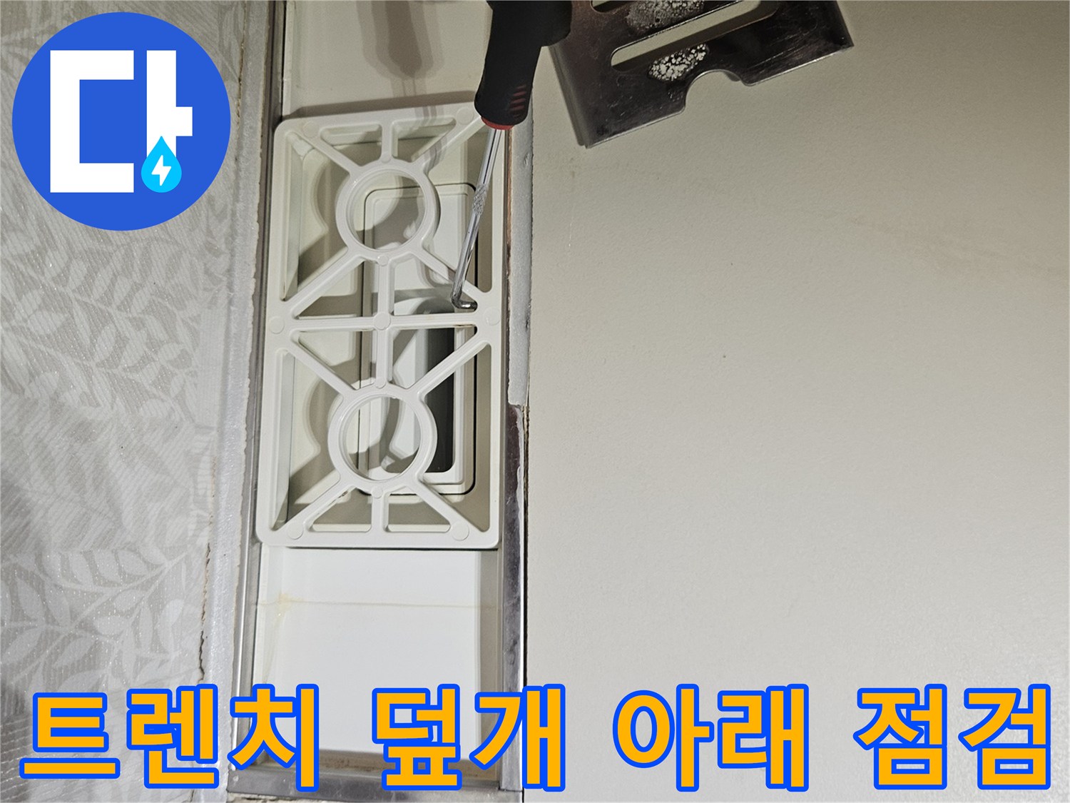 누수-엔지니어가-욕실-트렌치-덮개를-열고-그-아래-숨겨진-부분을-점검하는-모습