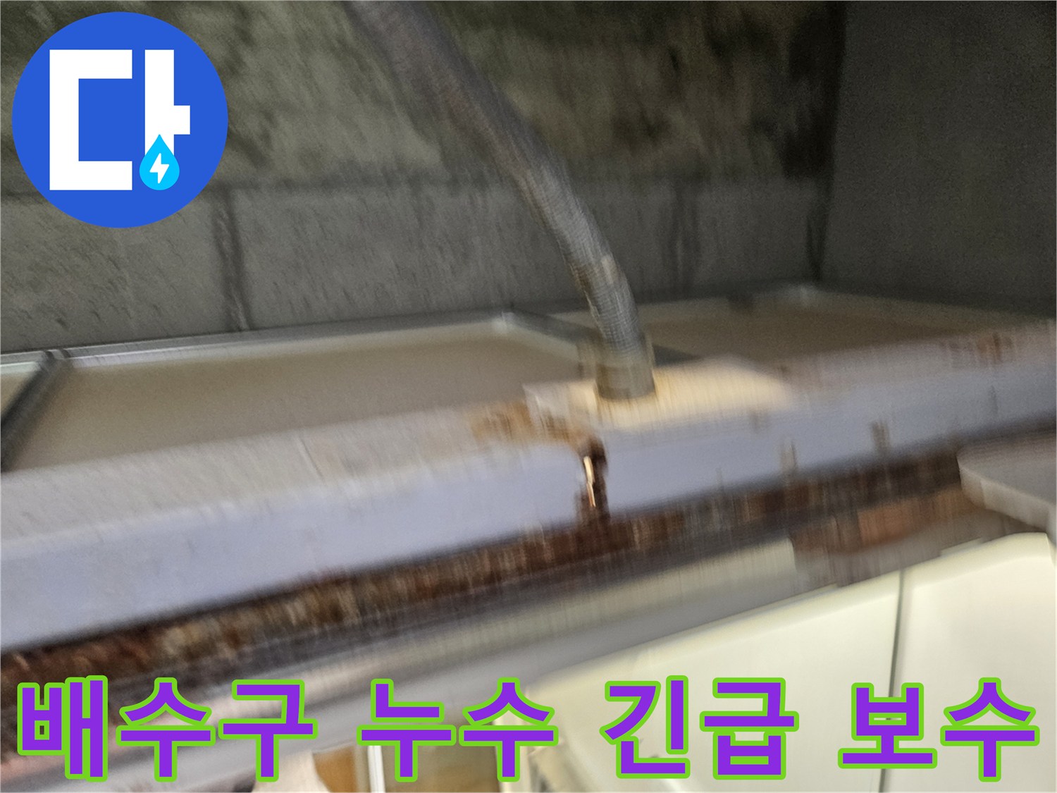 이 이미지는-베란다 배수구에서-발생한-누수를-긴급하게-보수하는-현장을-보여줍니다-전문가가-신속하게-대응하고-있습니다.