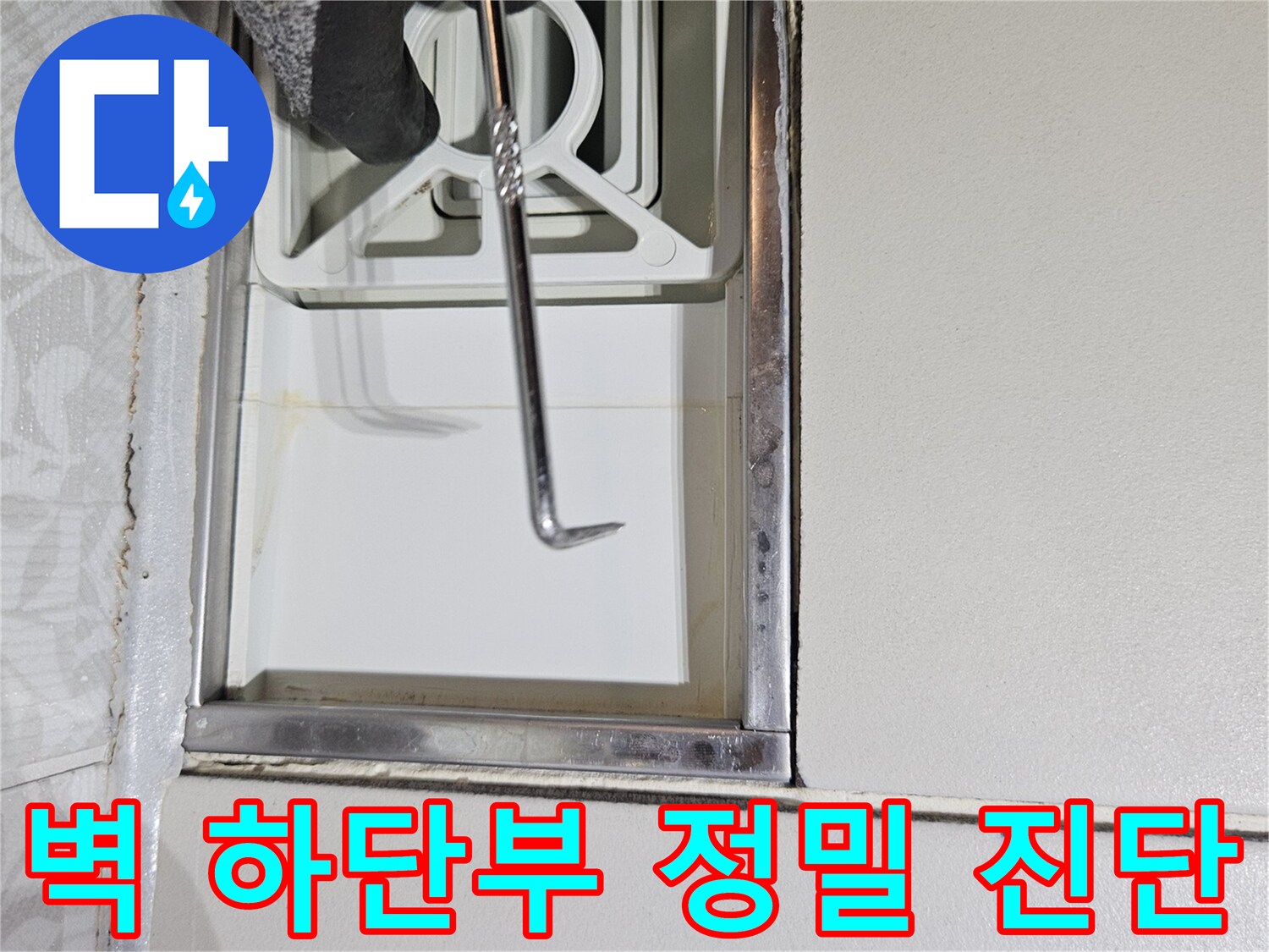 전문 누수 탐지사가-특수 도구로-벽면 하단부를-정밀하게-진단하며-누수 흔적을-찾는 모습입니다
