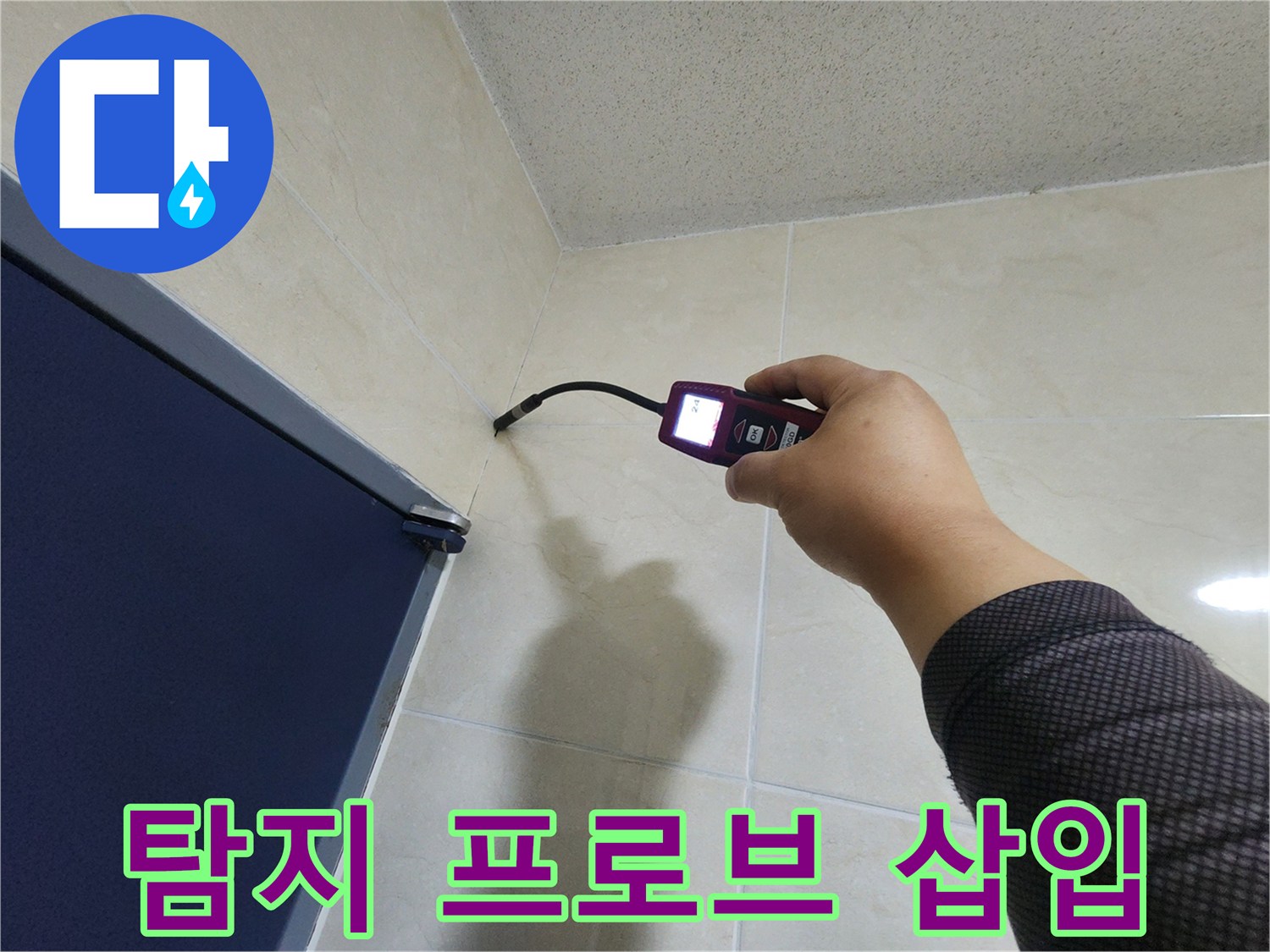 누수 전문가가-정밀 탐지 장비의 프로브를-벽면 틈새에 삽입하여-누수 원인을 분석하고 있습니다.