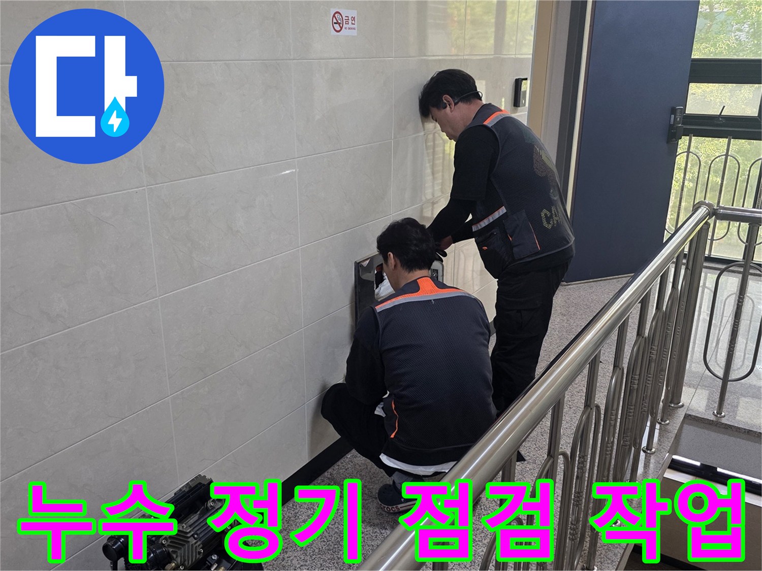 두 명의 전문 기술자가 건물 벽면의 누수 의심 지점을 정밀하게 점검하고 있습니다-정기적인 관리를 통해 안전한 주거 환경을 유지하기 위한 작업입니다.
