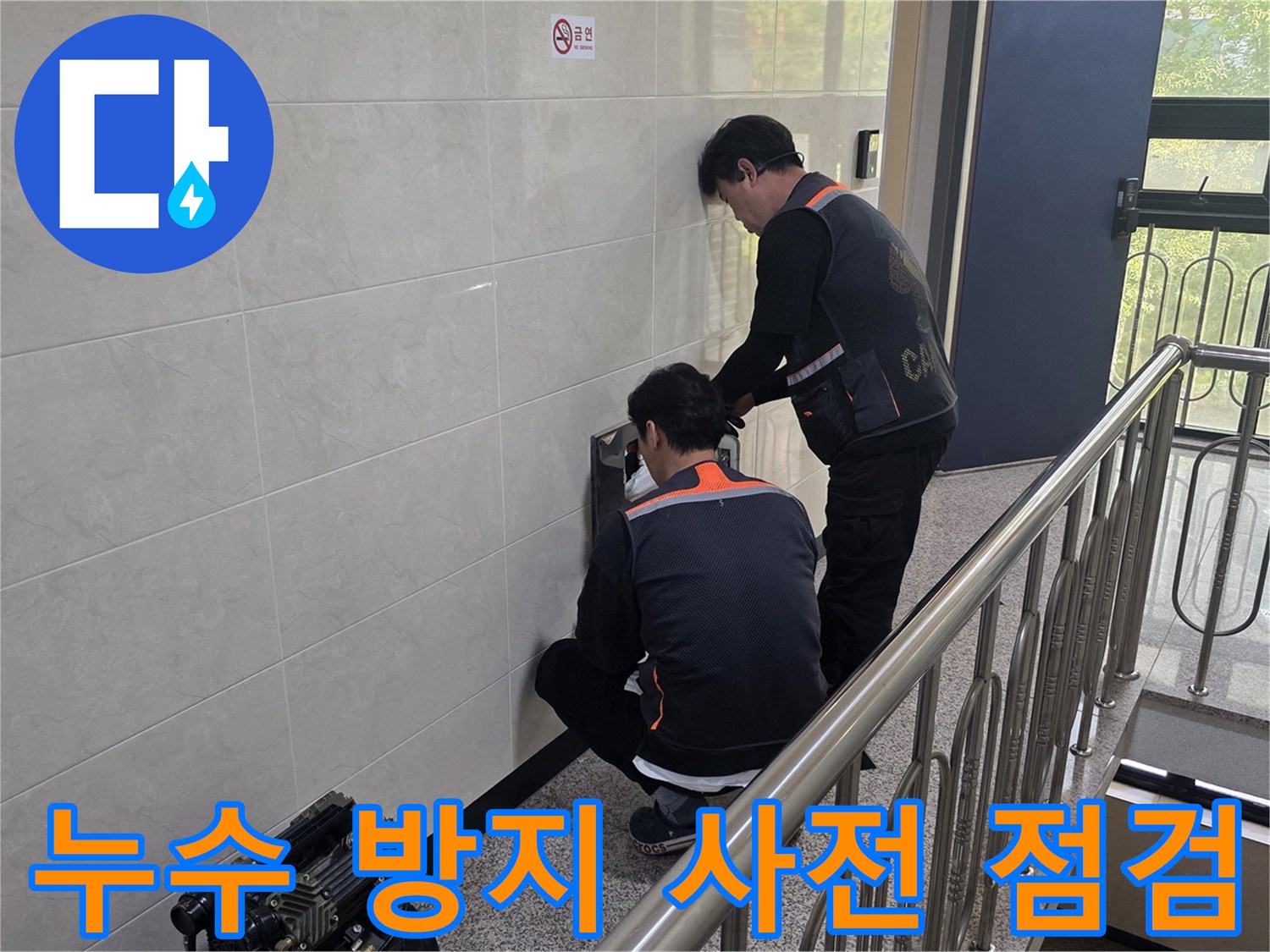 두 명의 전문 기술자가 건물 벽면의 누수 의심 지점을 정밀하게 탐지하며 누수 방지를 위한 사전 점검을 하고 있습니다-안전한 주거 환경을 위한 예방 활동입니다.