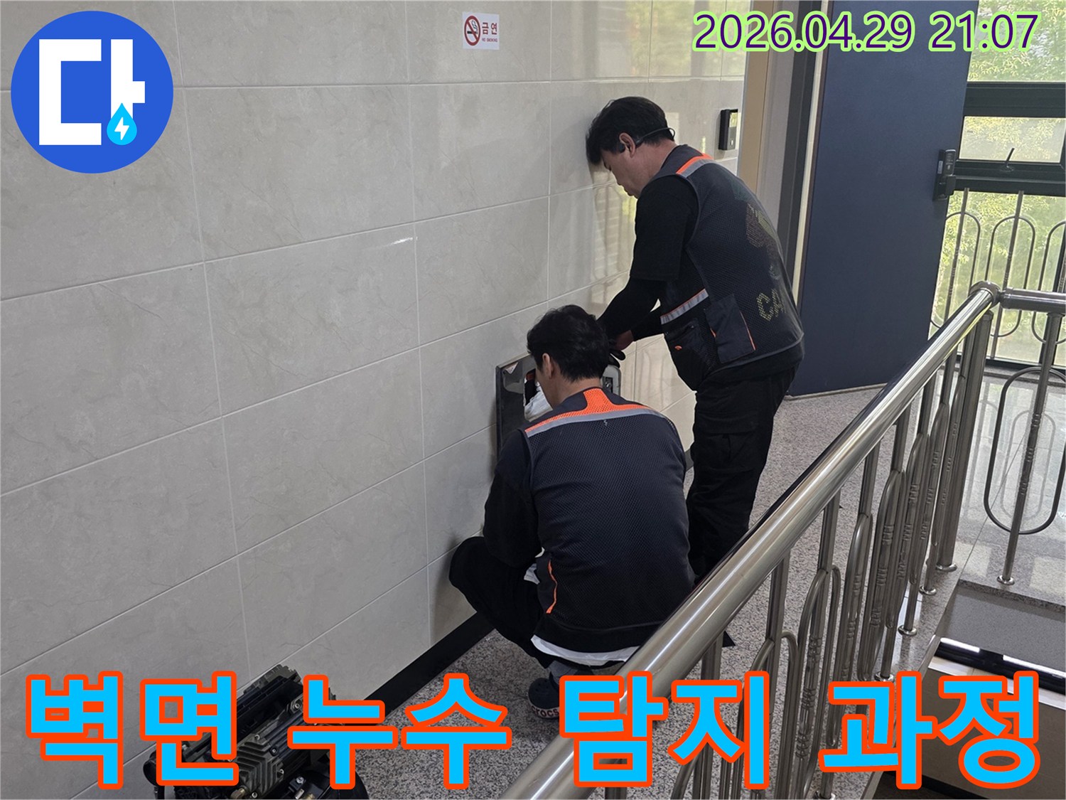 전문 엔지니어들이 건물 벽면의 누수 의심 부위를 집중적으로 탐지하고 있습니다-정확한 누수 지점을 찾아내기 위한 중요한 작업입니다.