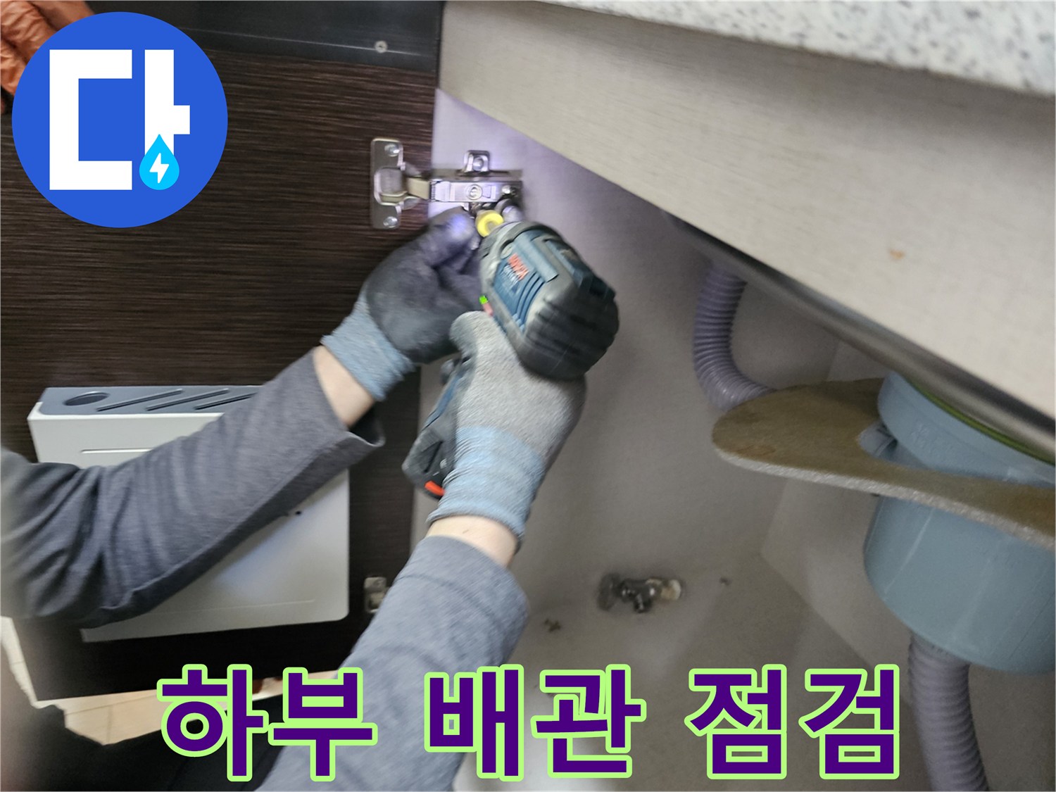 누수 엔지니어가-싱크대 하부의-배관을-점검하기 위해-패널을-분리하는-모습