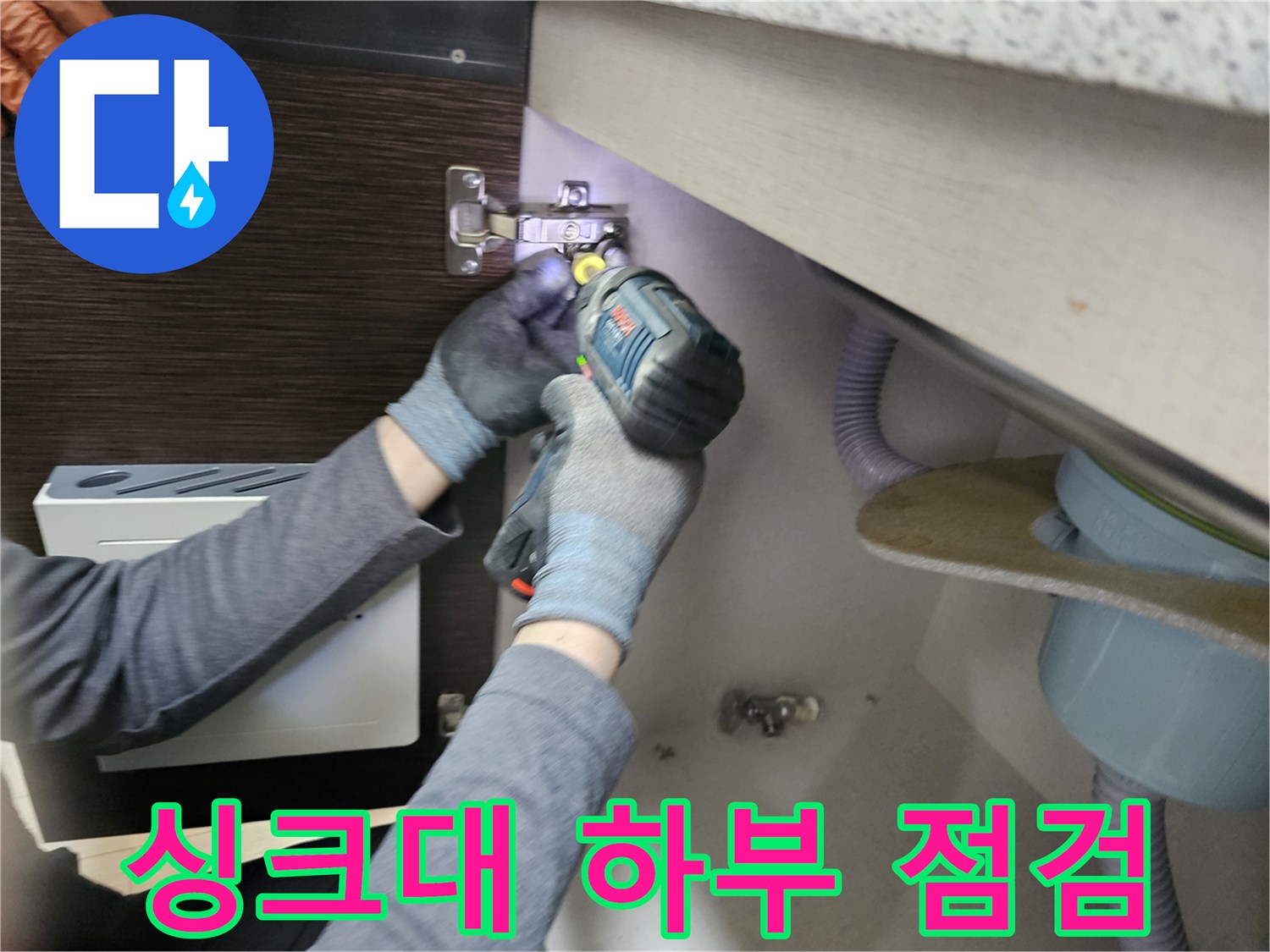 누수 전문가가-싱크대 하부를-점검하기 위해-패널을-분리하는-모습