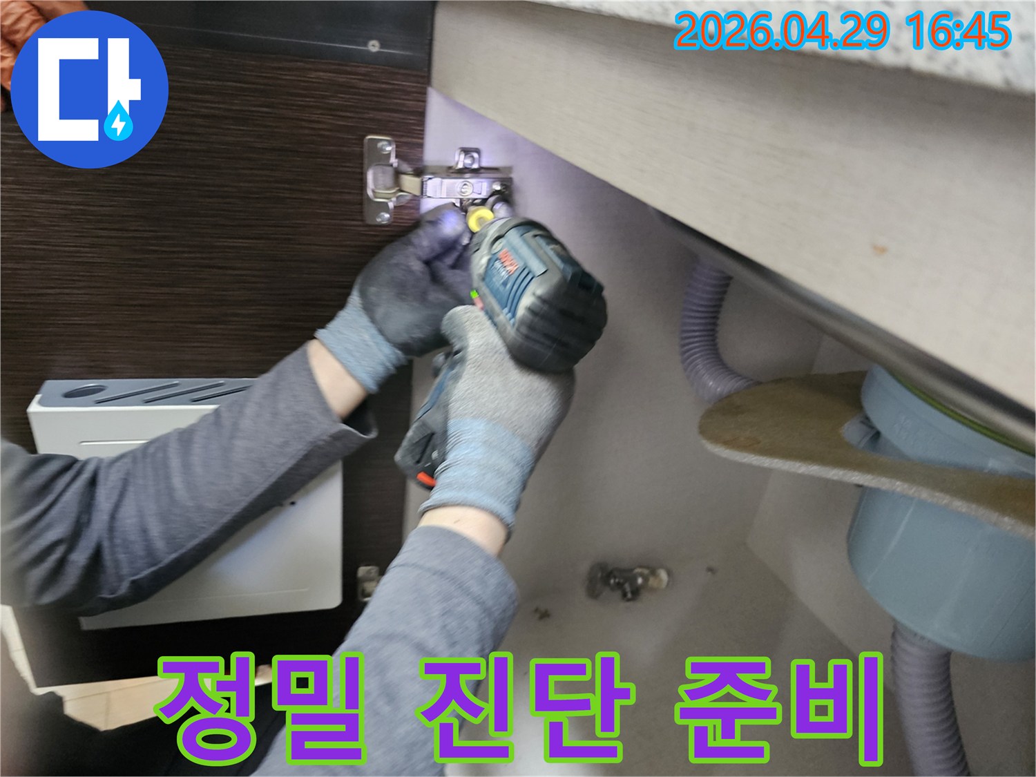 누수 전문가가-정밀 누수 진단을-위해-싱크대 하부장-패널을-분리하는-작업