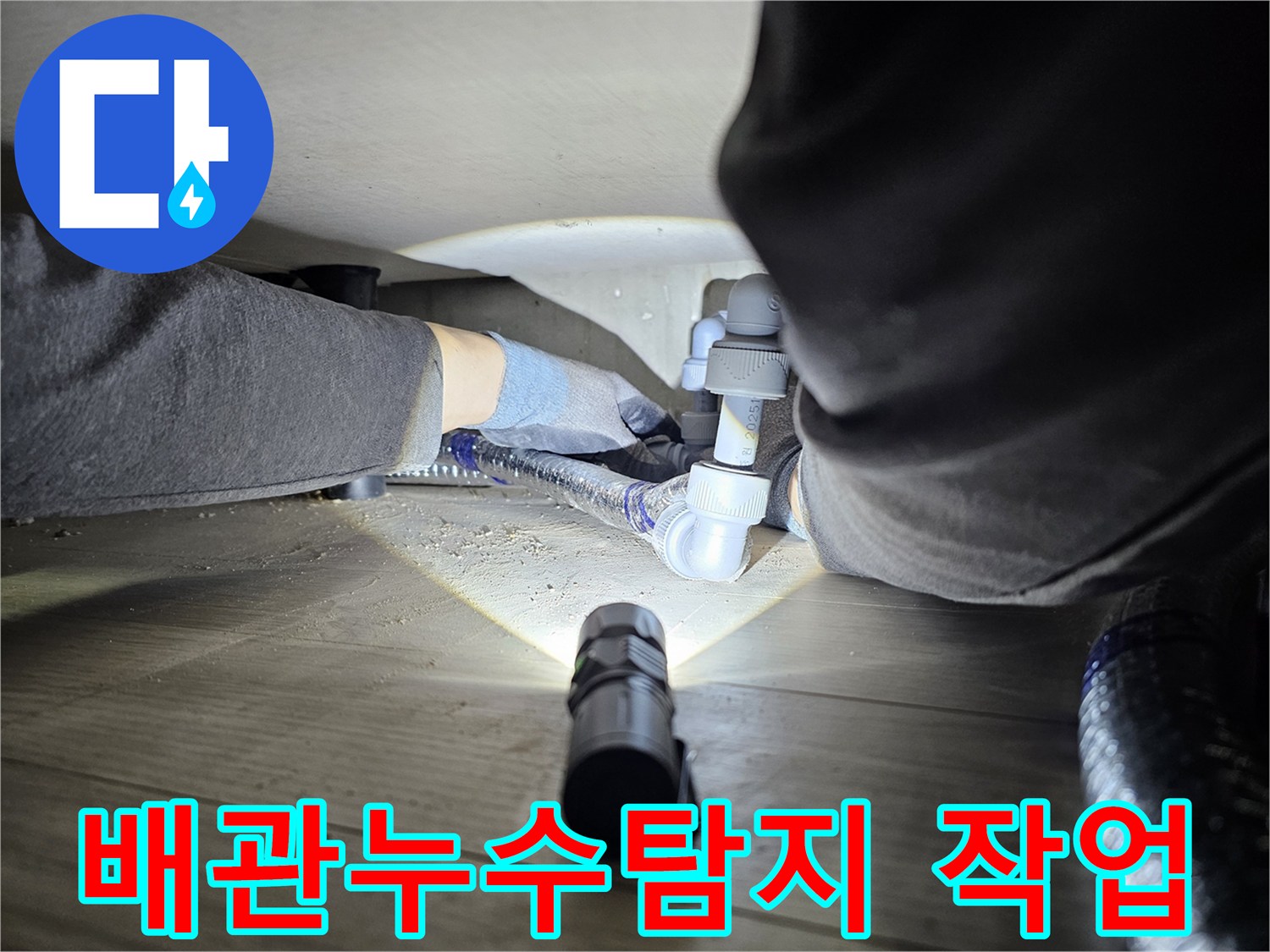 누수-탐지-전문가가-어두운-공간에서-배관-연결부를-확인하는-모습