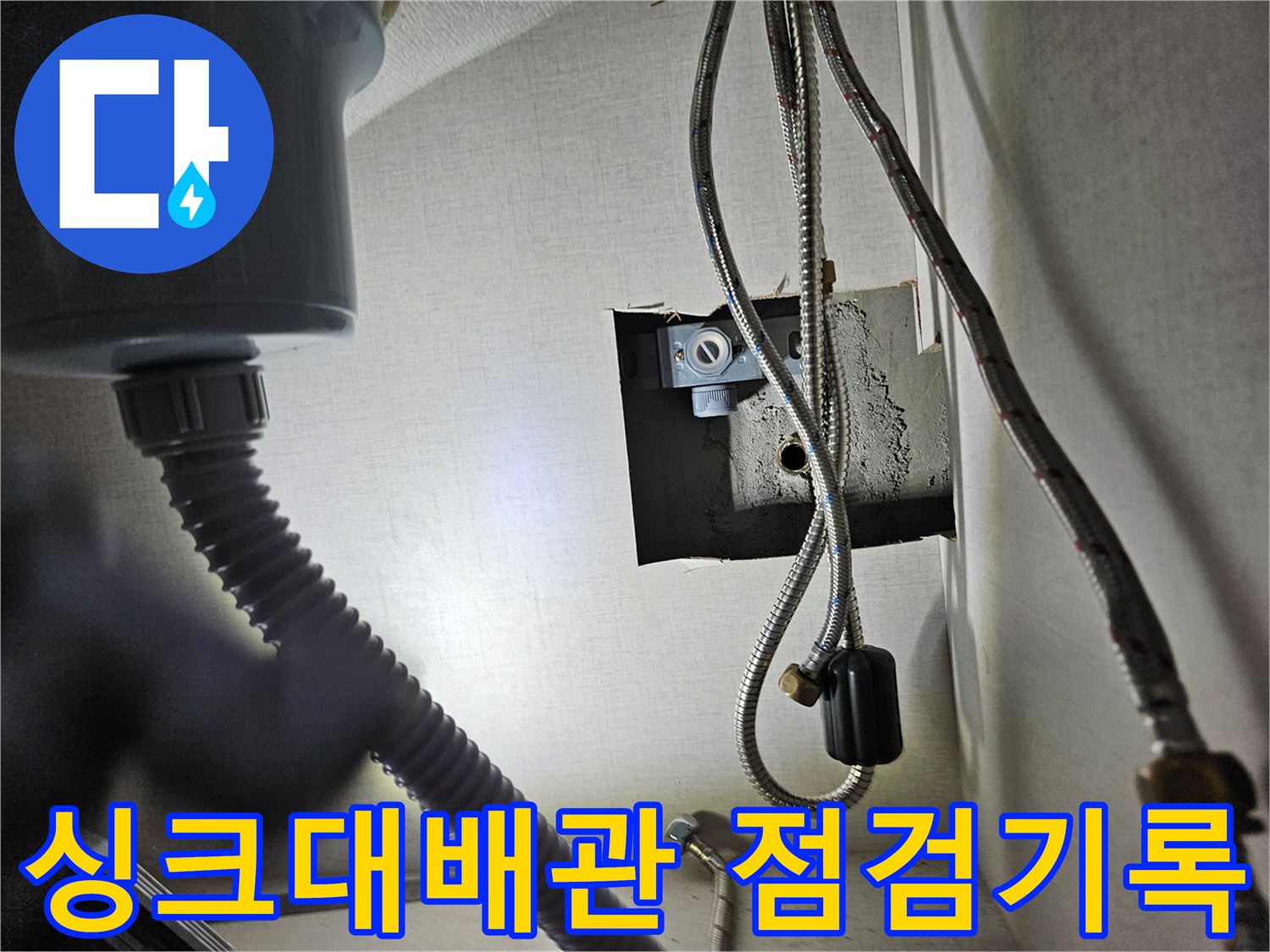 싱크대 하부장 내부의-수도 배관 시스템을-점검하며-누수 여부를-기록하는 모습입니다.