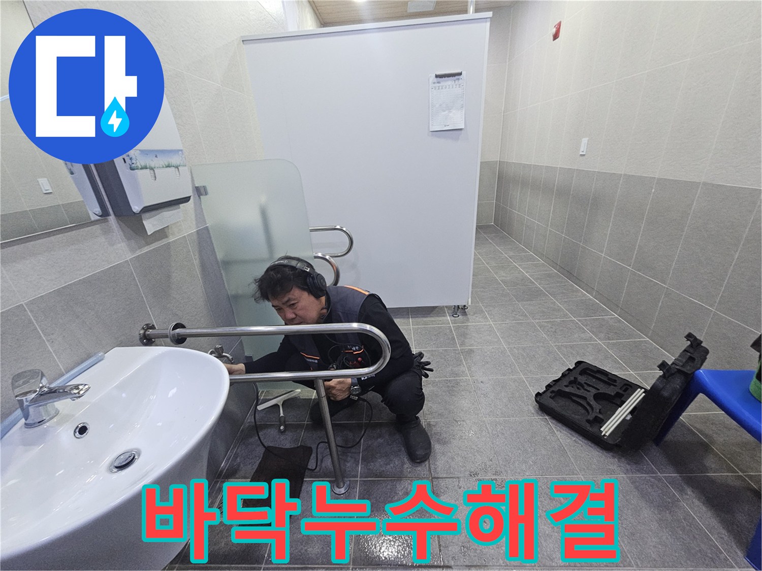누수 전문 엔지니어가-청음식 탐지 장비로-욕실 바닥의 누수 지점을 정밀하게 확인하고 있습니다.