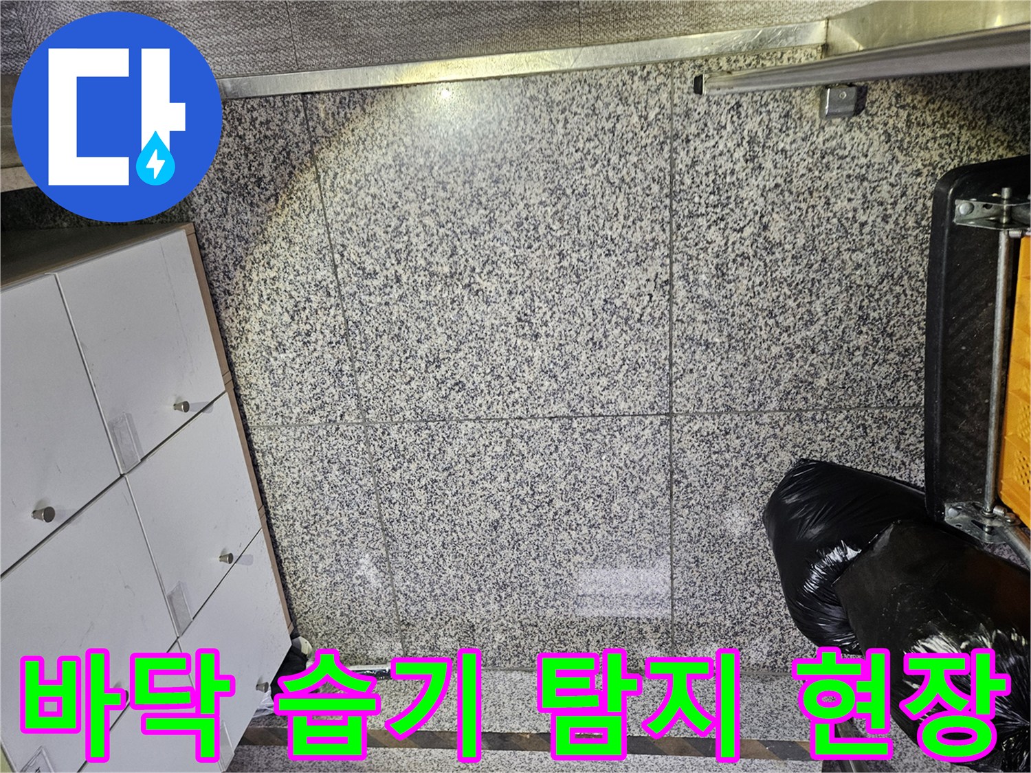 포천 상가 건물에서-바닥 타일의 젖은 부분을 발견하여-누수 전문가가 현장을 면밀히 살피는-초기 진단 단계입니다