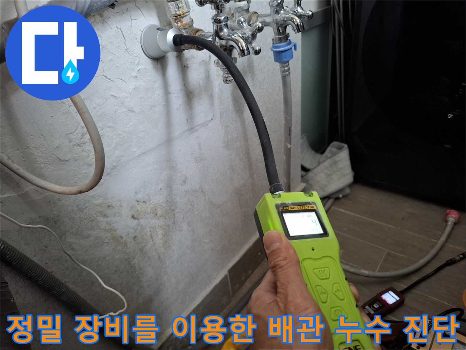 가스 탐지기를 사용하여 벽면 내부의 물샘 지점을 추적하는 작업자
