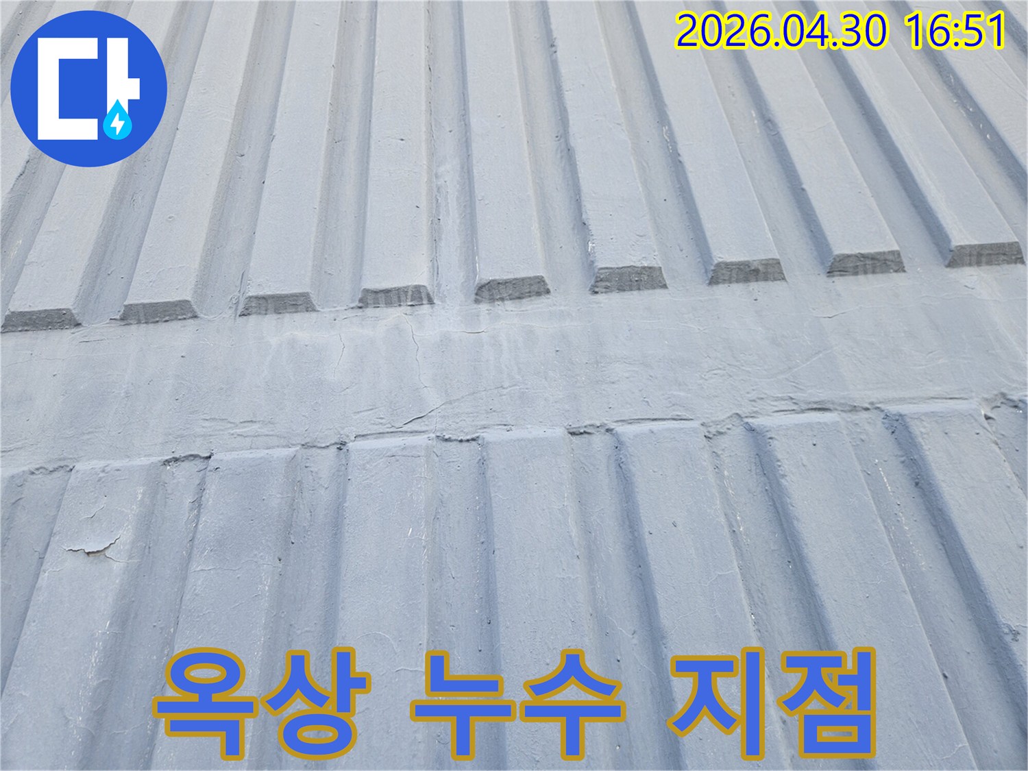 회색 골진 옥상 표면의 이음새 부분에서-누수가 시작되는 지점을 명확히 보여주는 사진