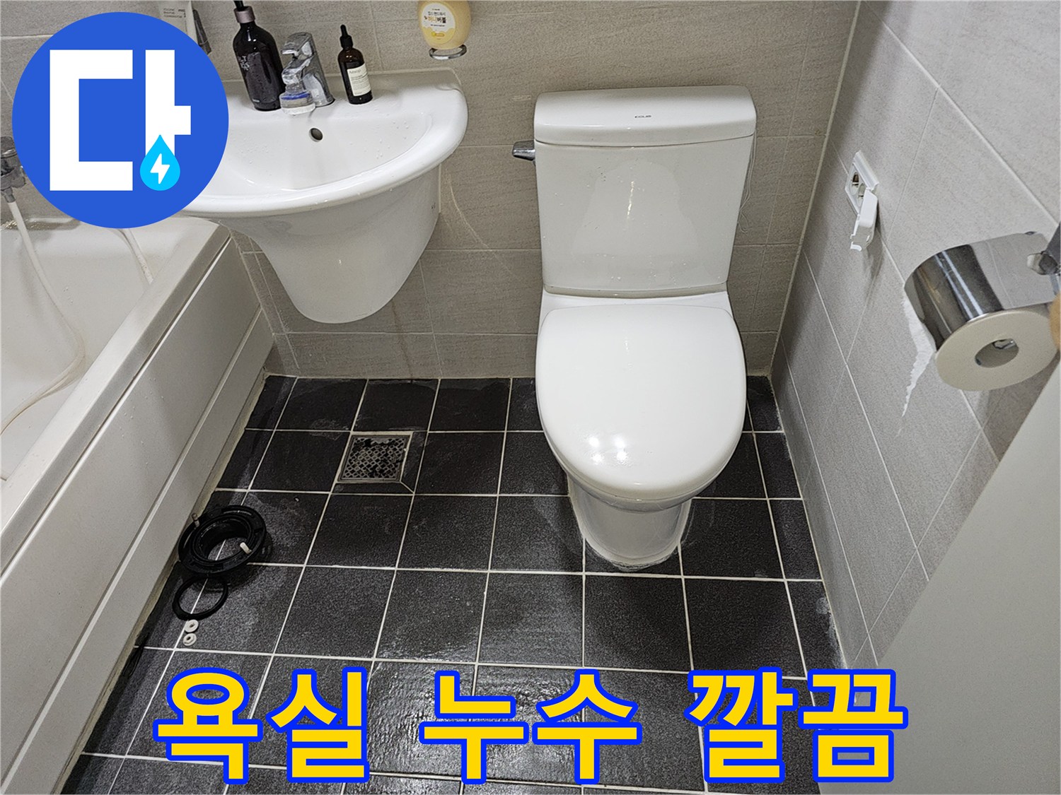 누수 공사 완료 후-새롭게 단장된-욕실의-변기와-세면대-바닥 타일입니다.