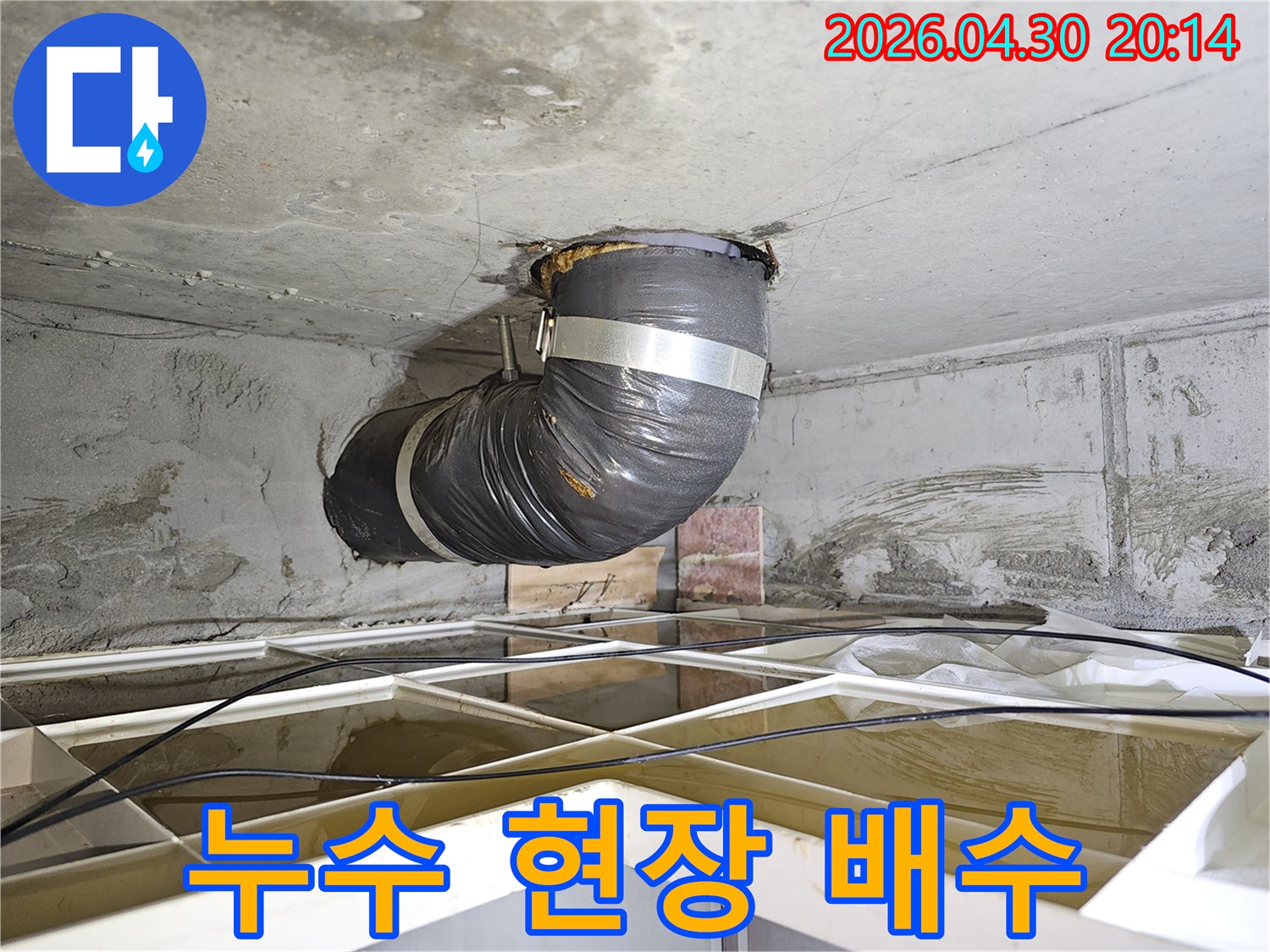 상가 천장 누수 현장에서-물 피해 확산을 막기 위해-설치된 임시 배수 배관의 모습입니다.
