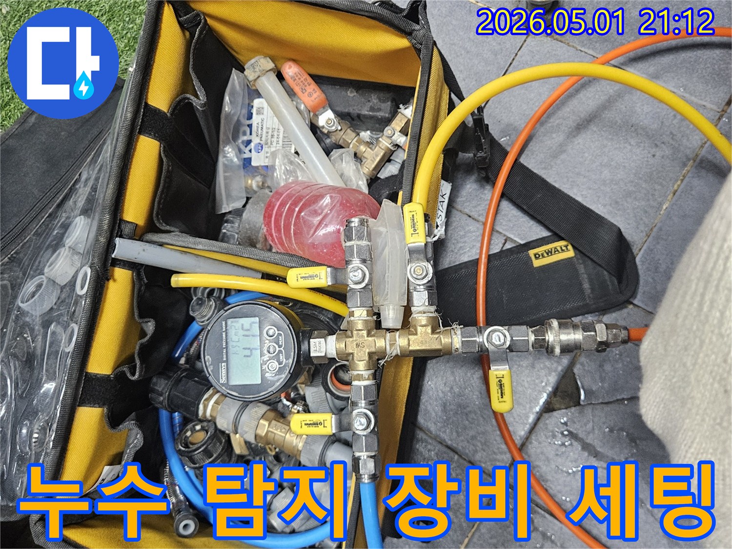 누수 탐지를 위해 압력 테스트 장비를 배관에 연결하고 있는 전문 기술자의 모습입니다-정확한 진단을 위한 세심한 작업입니다.