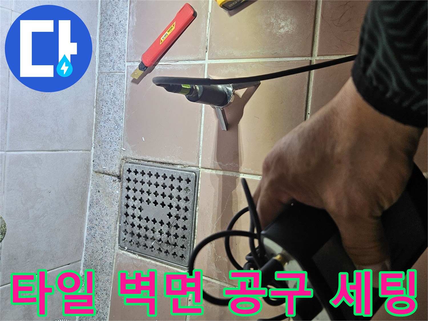 배관 수리를 위해 타일 벽면에 배치된 전동 드릴과 커터기