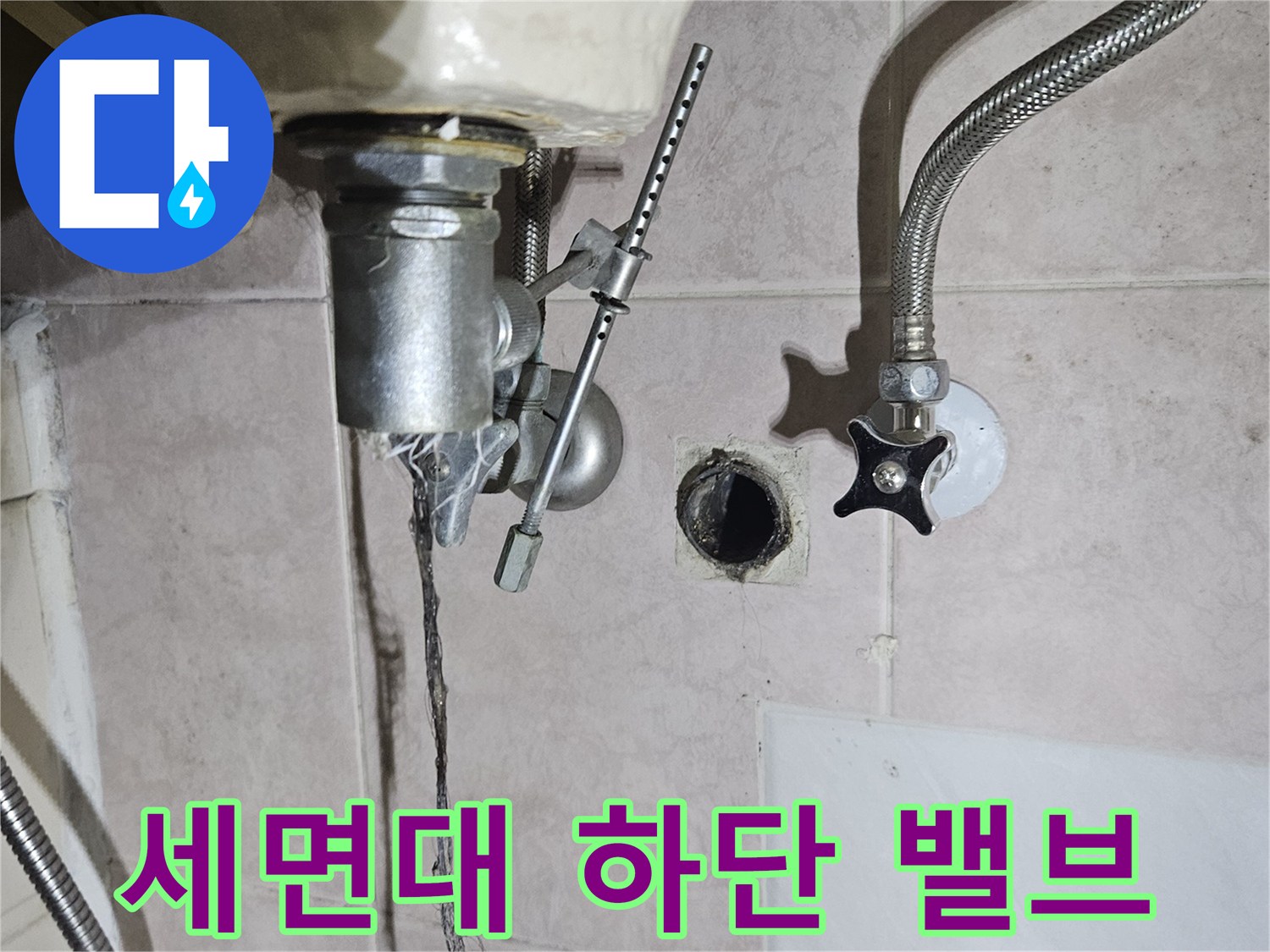 세면대 아래 벽면 타일과 연결된 수도 밸브 부근 모습