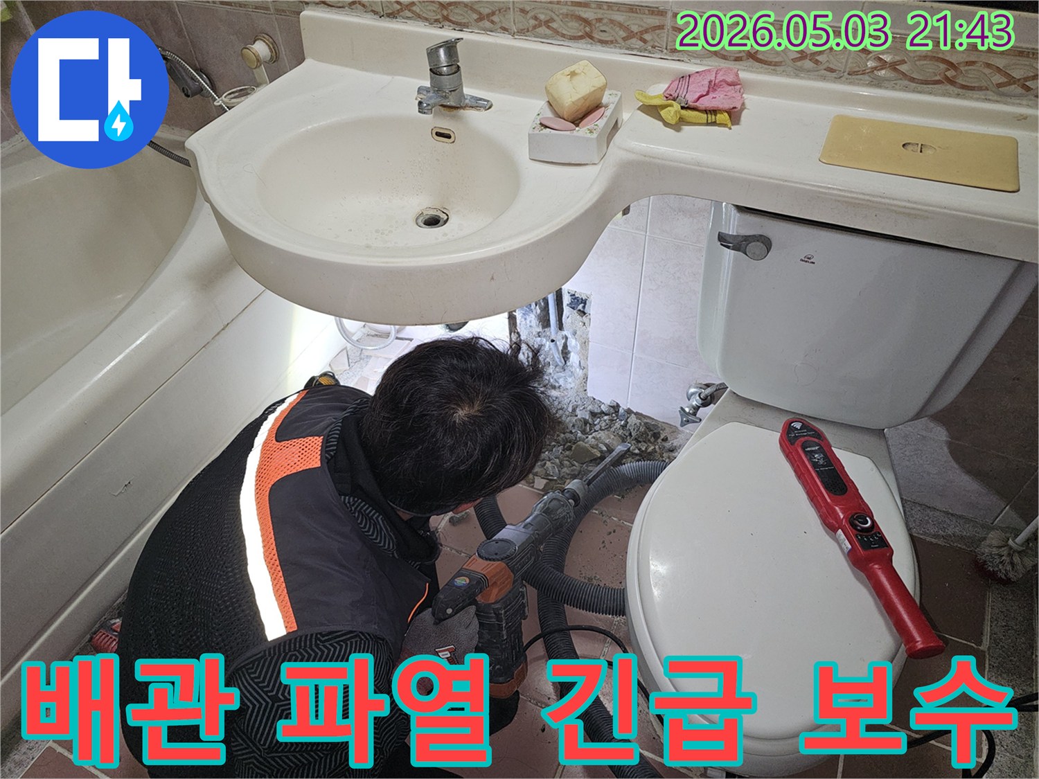 욕실 바닥 아래에서 발생한 배관 파열을-신속하게 해결하기 위해-전문가가 파쇄 작업을 진행하는 현장입니다.