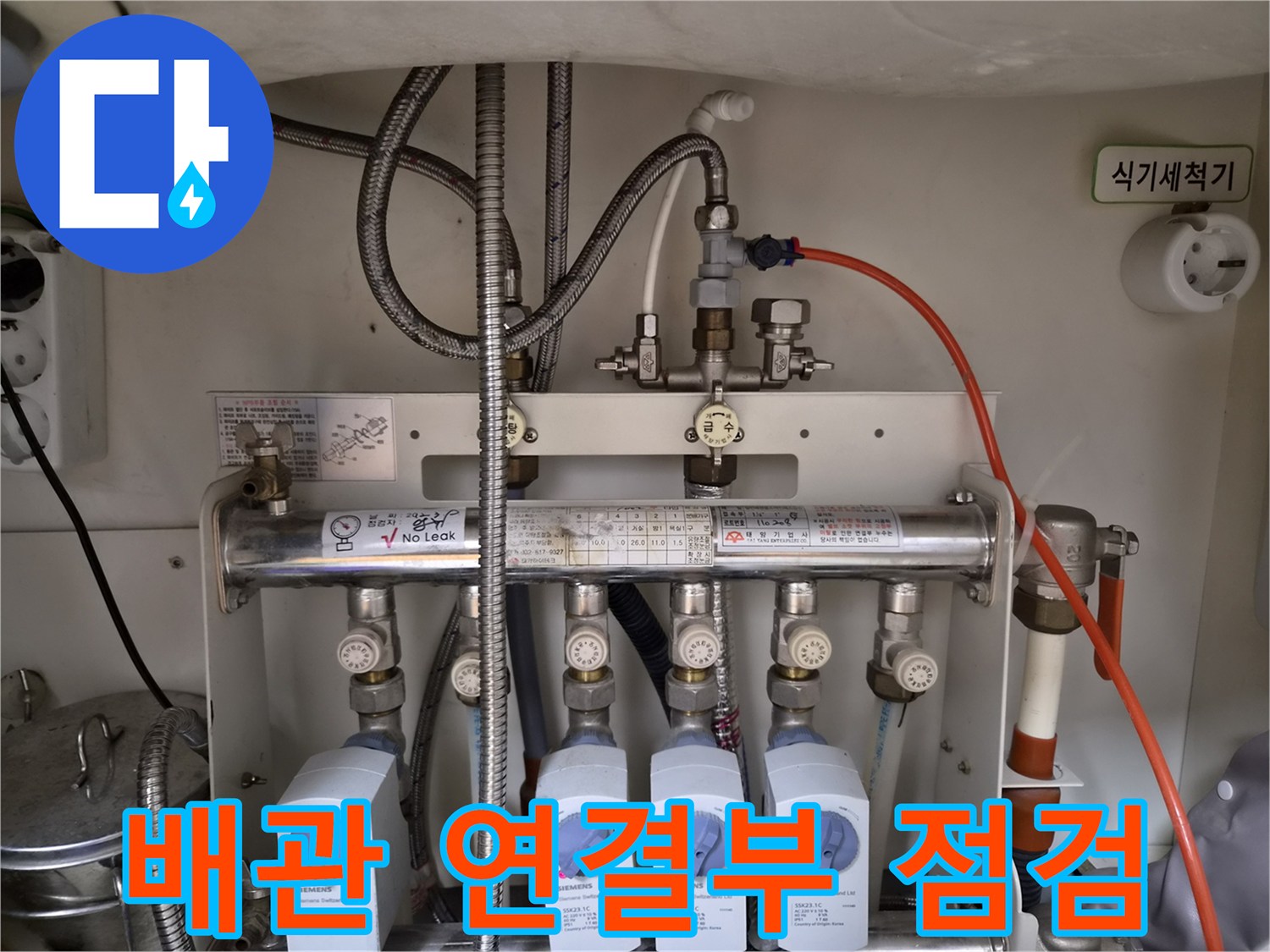 은색 호스와 금속 분배기 밸브가 결합된 모습
