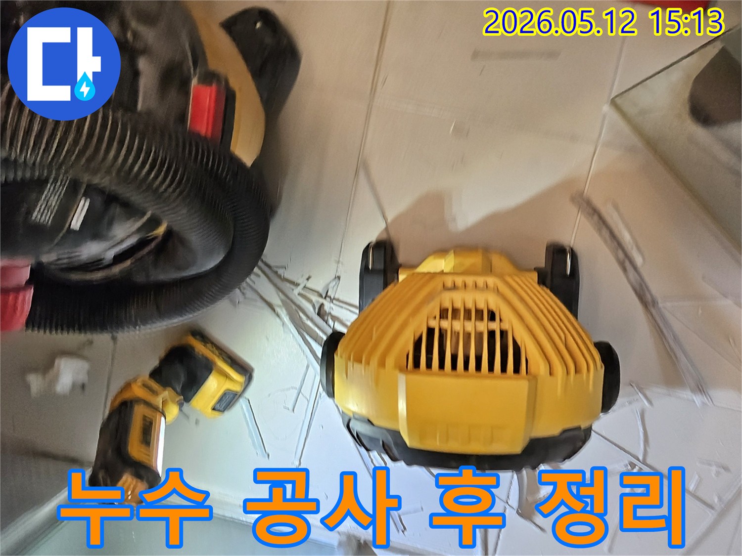 누수 공사 완료 후-현장을 깨끗하게 정리하는 모습-작업등과 청소 장비가 보입니다