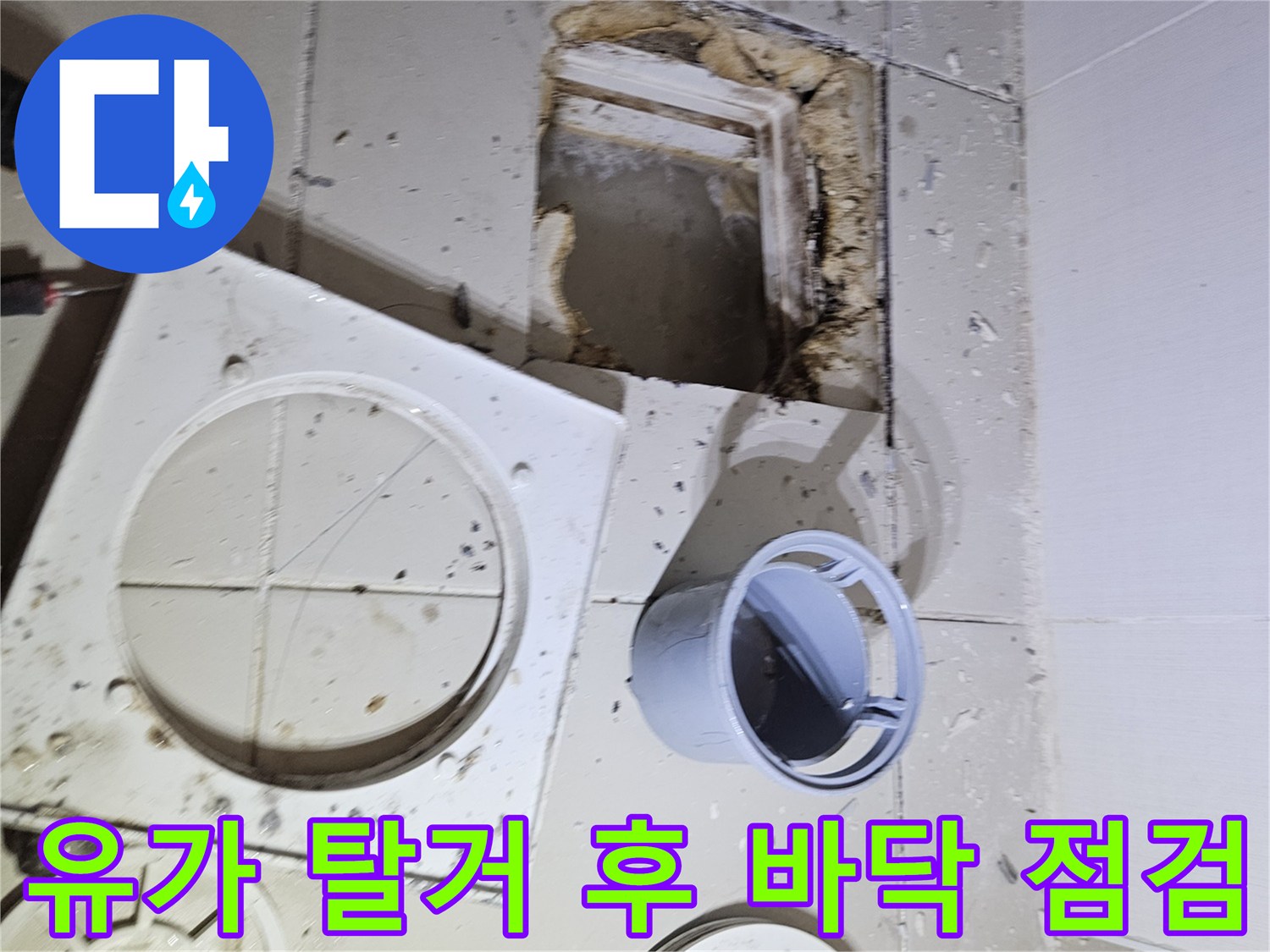 욕실 유가 덮개를 분리하고 타일을 깨서 배관을 노출시킨 장면