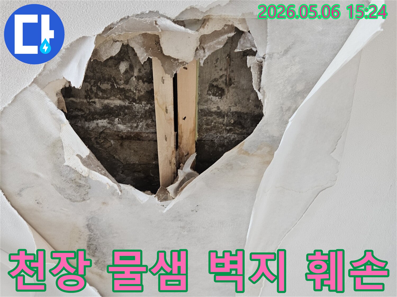 아파트 천장에서 물이 새어 벽지가 심하게 손상되고-내부 구조물이 드러난 누수 현장 사진입니다.