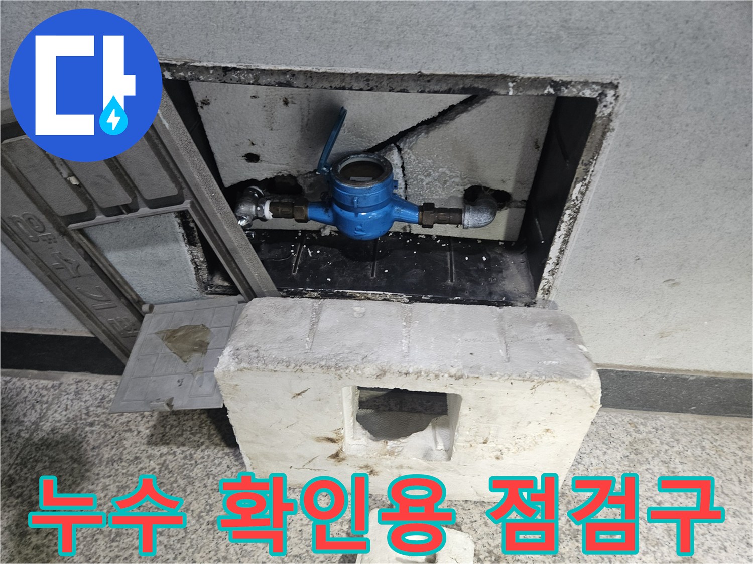 점검구 내부의 파란색 밸브와 노출된 배관 부속