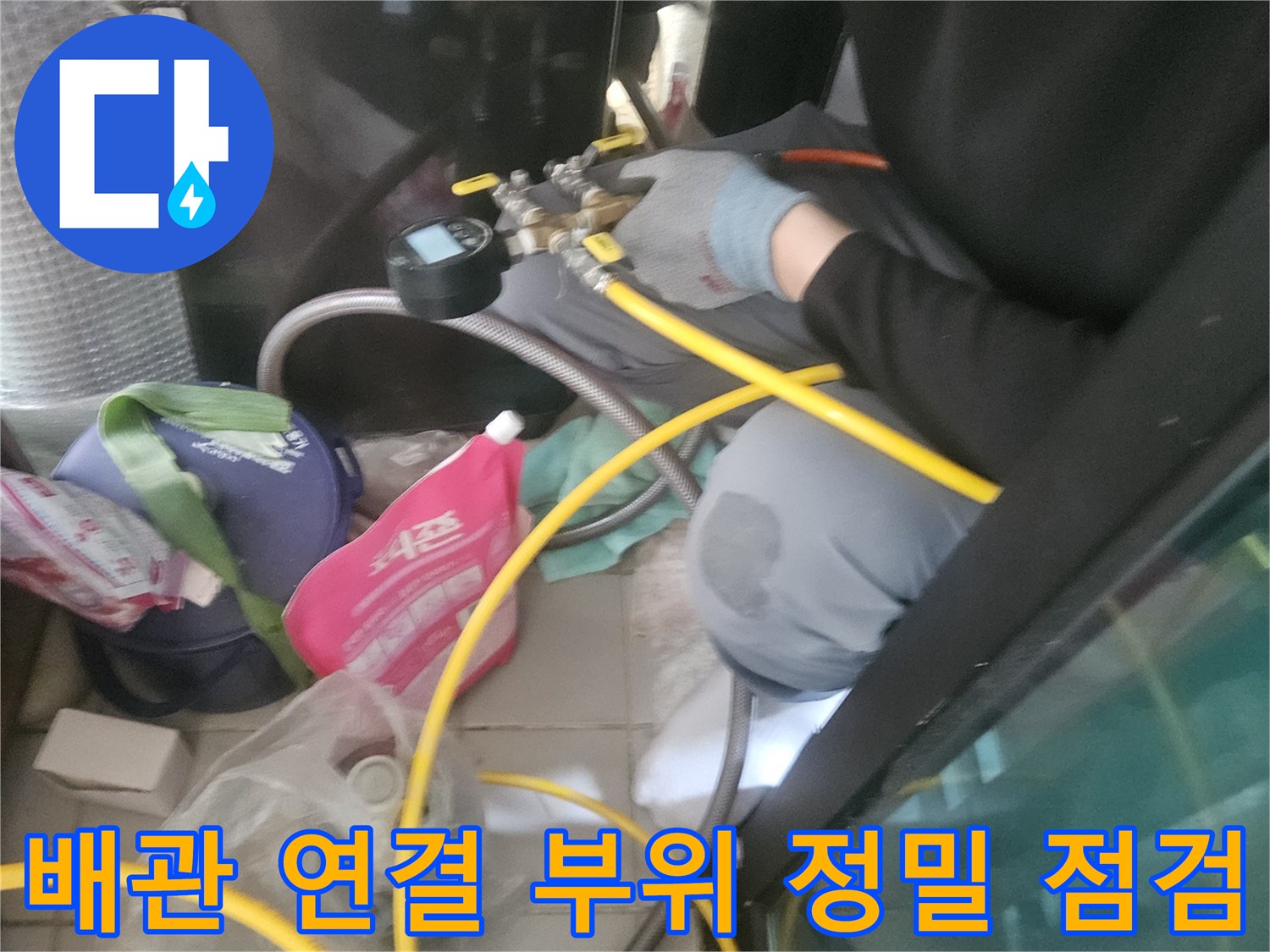 노란색 호스가 연결된-배관 연결 부위를 면밀히 관찰함