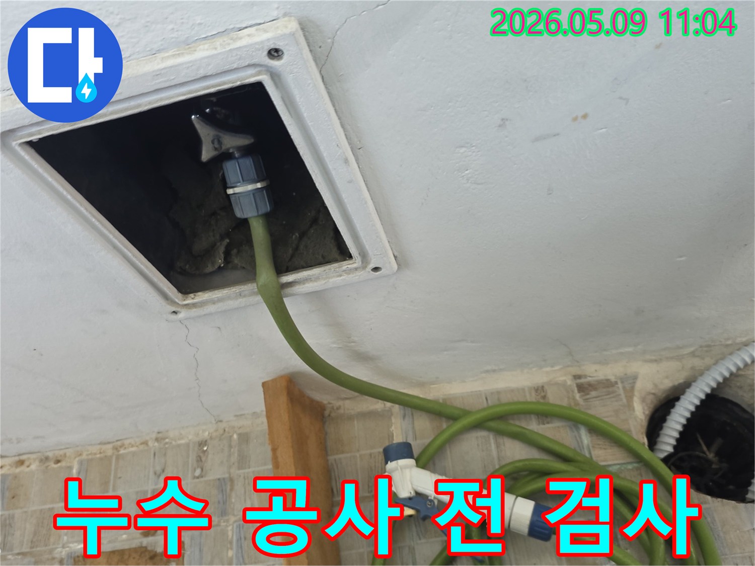 누수 공사 전 천장 점검구에 탐지 호스를 연결하여 내부를 정밀하게 검사하는 모습