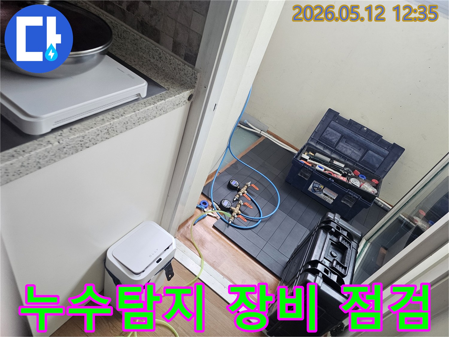 누수 탐지 작업을 시작하기 전-전문 엔지니어가-장비의 상태를 꼼꼼히 점검하며-배관에 연결하는 모습