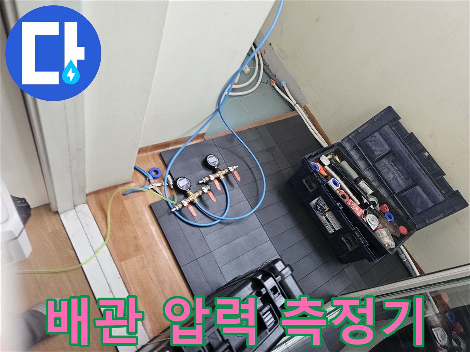 타일 바닥 위에서 작동 중인 공압 테스트용 게이지와 연결 호스