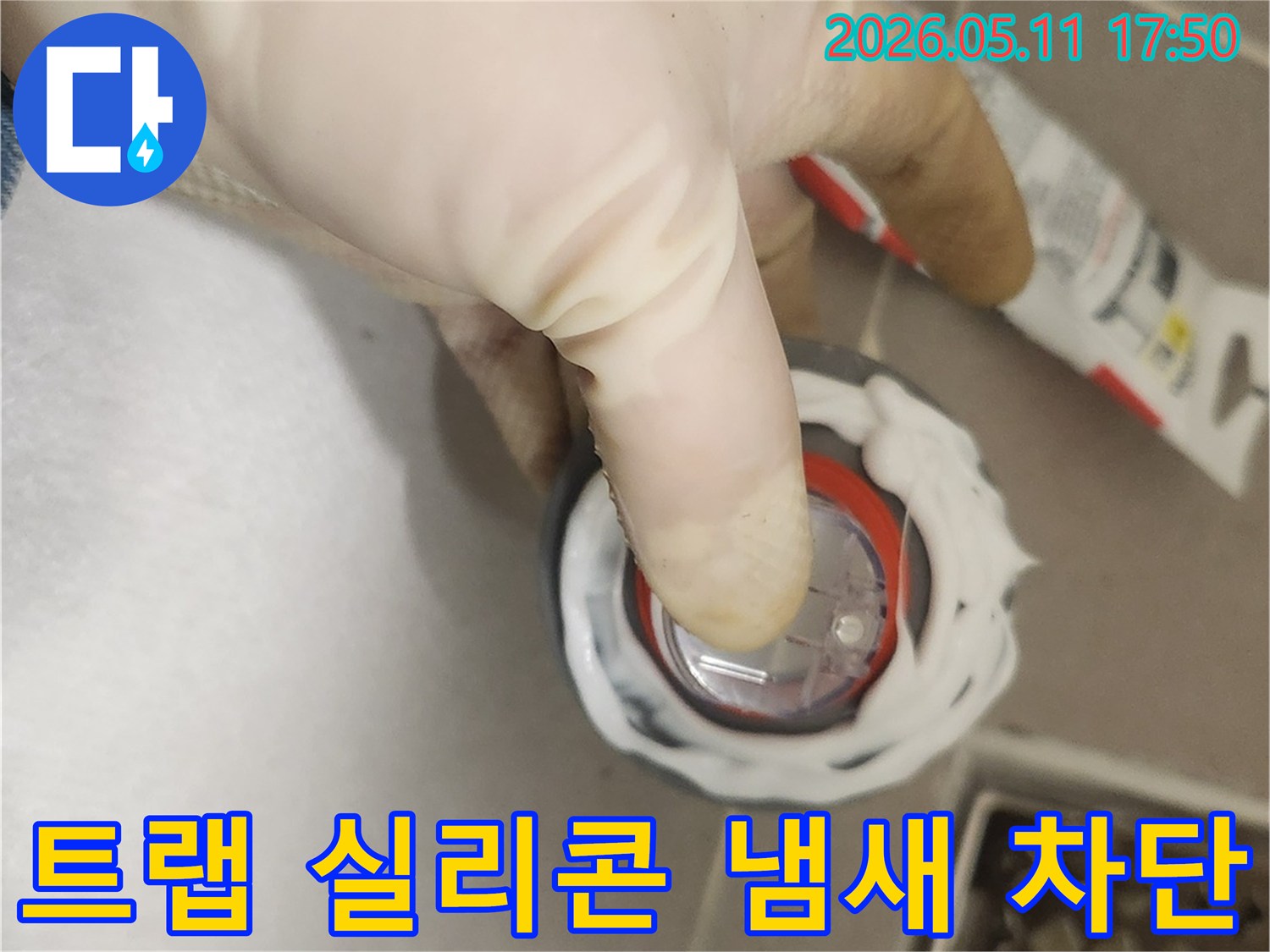 배수구 트랩 주변에-실리콘을 도포하여-냄새와 벌레 유입을-동시에 차단하는 모습입니다