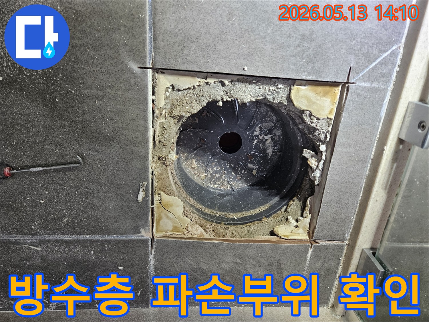 욕실 바닥의 방수층이 파손되어 누수가 발생한 지점을 확인하기 위해-타일을 제거하고-내부 구조를 노출시킨 상태입니다