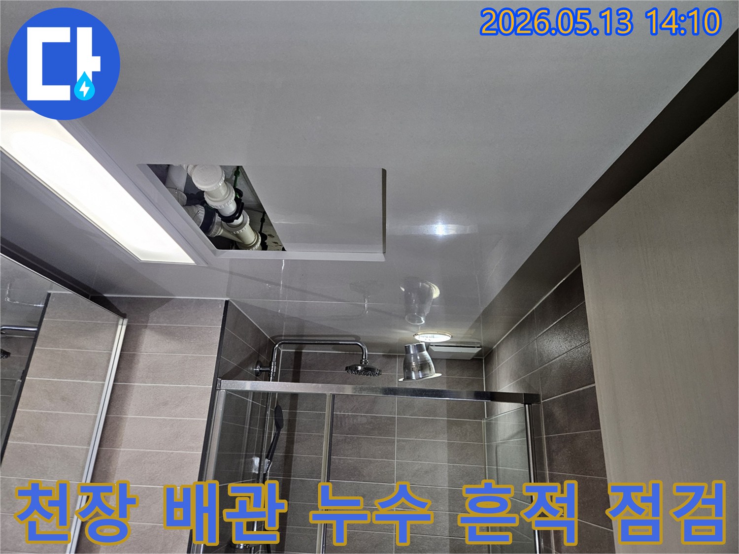 천장 점검구를 통해-내부 배관에서-발견된-누수 흔적을-정밀하게-점검하고-있는-전문가의-모습입니다