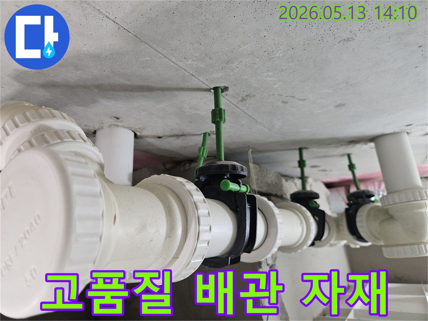 콘크리트 천장에 설치된 고품질 흰색 PVC 배관과-내구성이 뛰어난 검은색 밸브들의 견고한 연결 모습