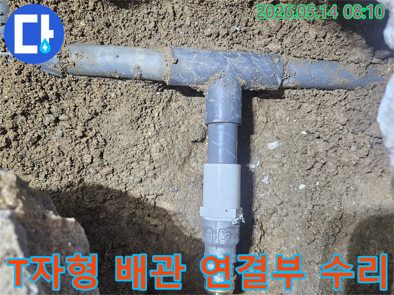 땅속에 매립된 수도배관의 T자형 분기점에서-누수가 발생하여-새로운 연결 부속으로 교체하는 작업 현장입니다
