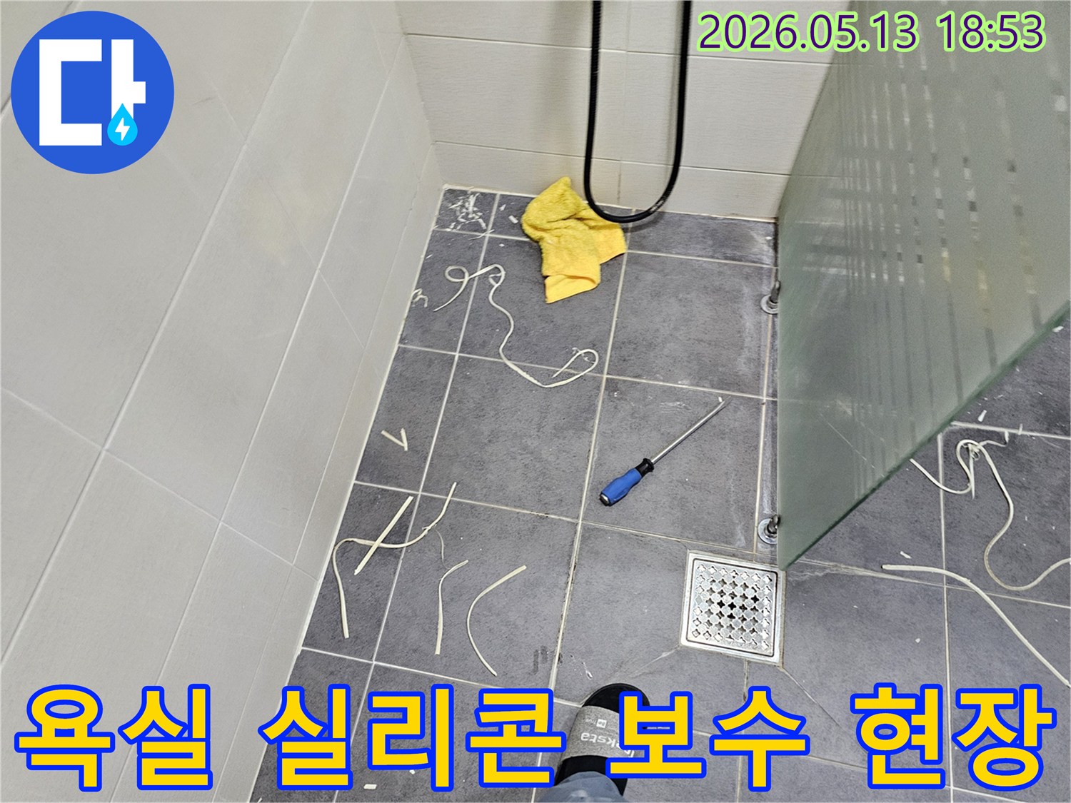 욕실 바닥 타일과-샤워부스-주변의-실리콘-제거-작업-후-모습을-보여주는-사진입니다
