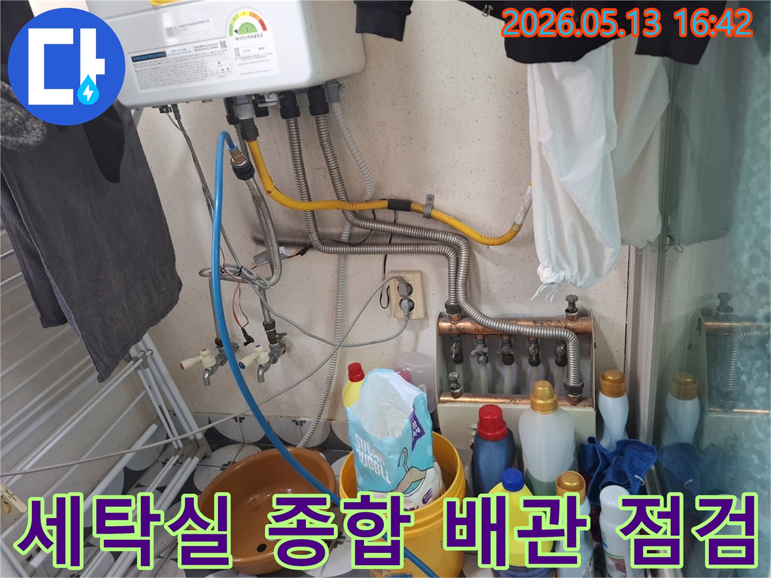 세탁실 보일러 하단부의-모든 배관 연결 부위에서-누수 여부를 종합적으로 점검하는 모습