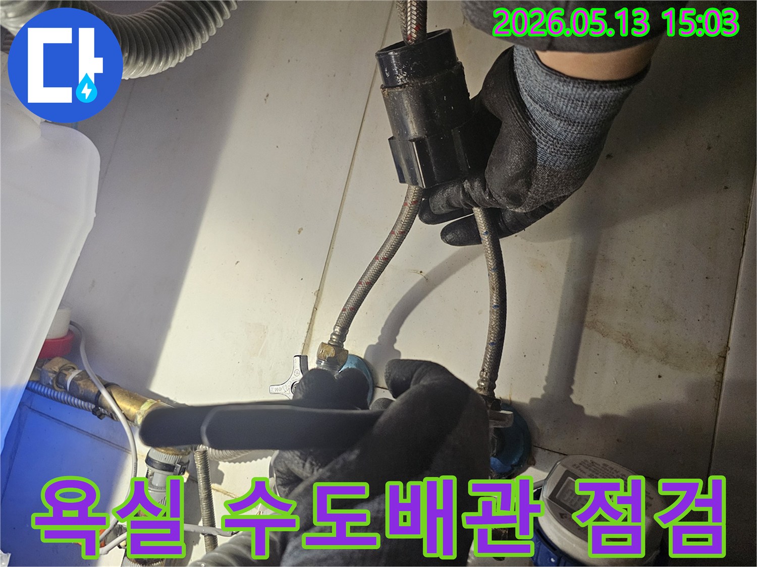 전문 기술자가-욕실 내부의-수도 배관 연결 부위를-꼼꼼하게 점검하며-누수 흔적을-찾아내고 있습니다