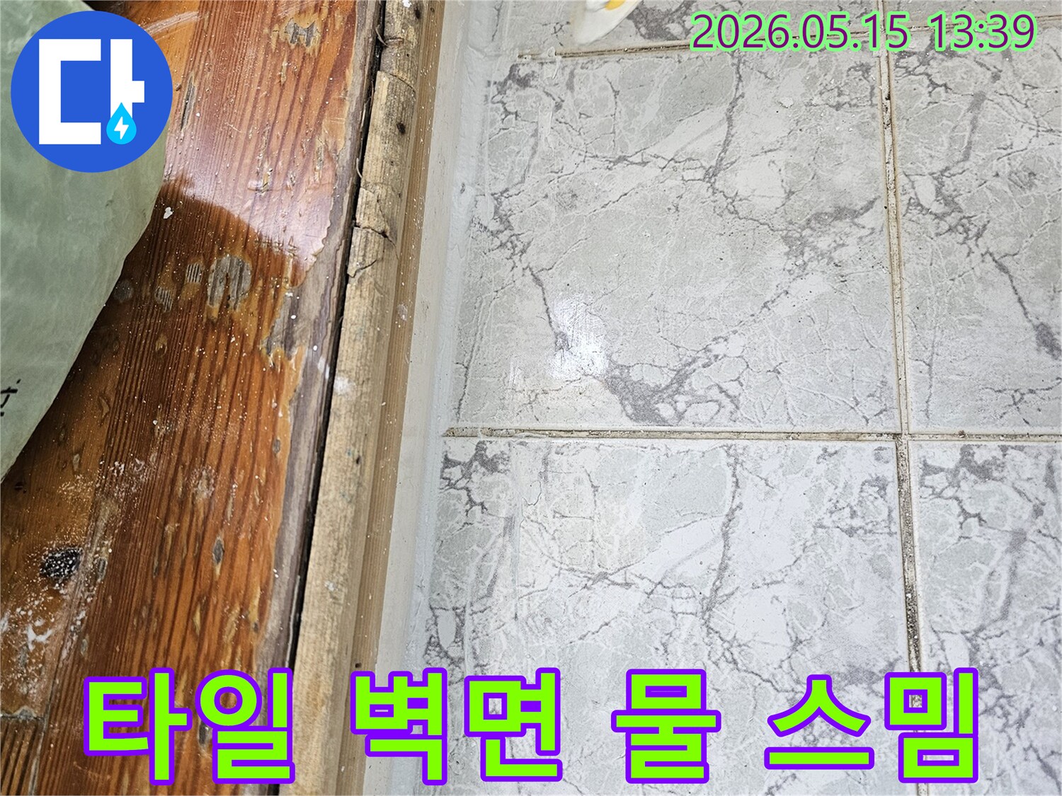 이 이미지는-의정부 신곡동의 한 현장에서-타일 벽면 하단부에 물이 스며든 현상을 보여주며-누수탐지가 필요한 상황입니다