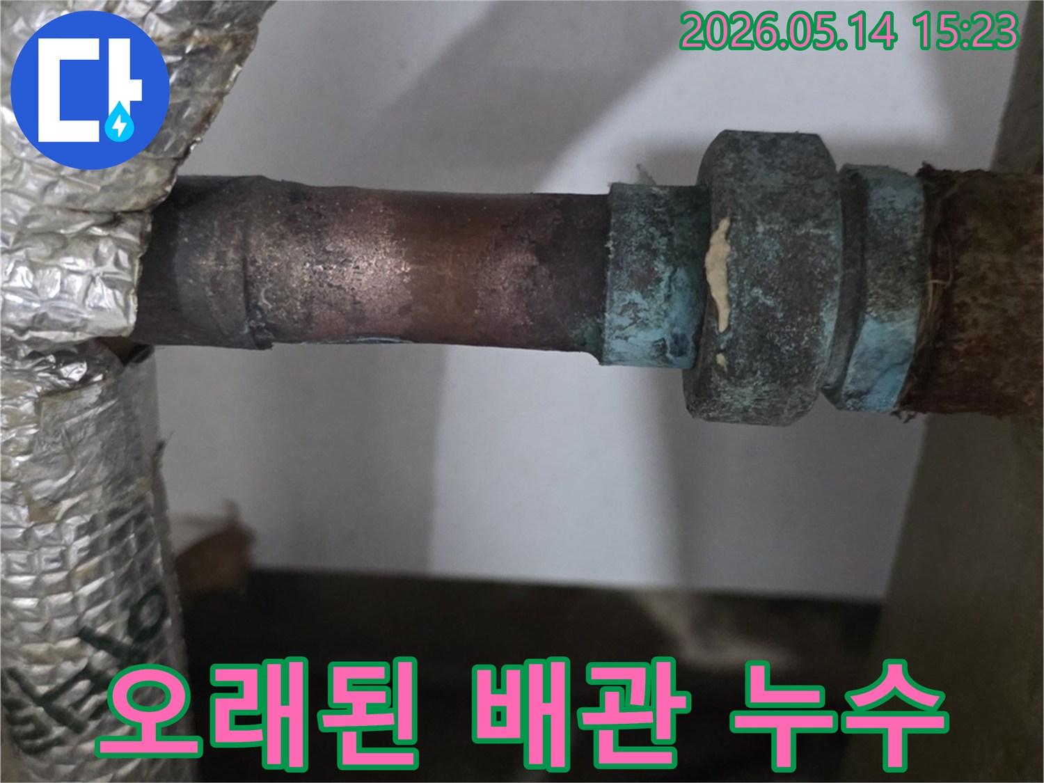 수도관-이음새의-녹과-청록색-부식은-배관-노후화의-명확한-증거이며-전문-기술자가-누수-지점을-정밀하게-확인하고-있습니다