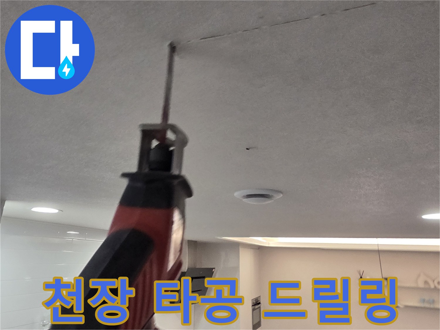 드릴을 이용하여 천장 마감재를 뚫고 있는 작업 장면