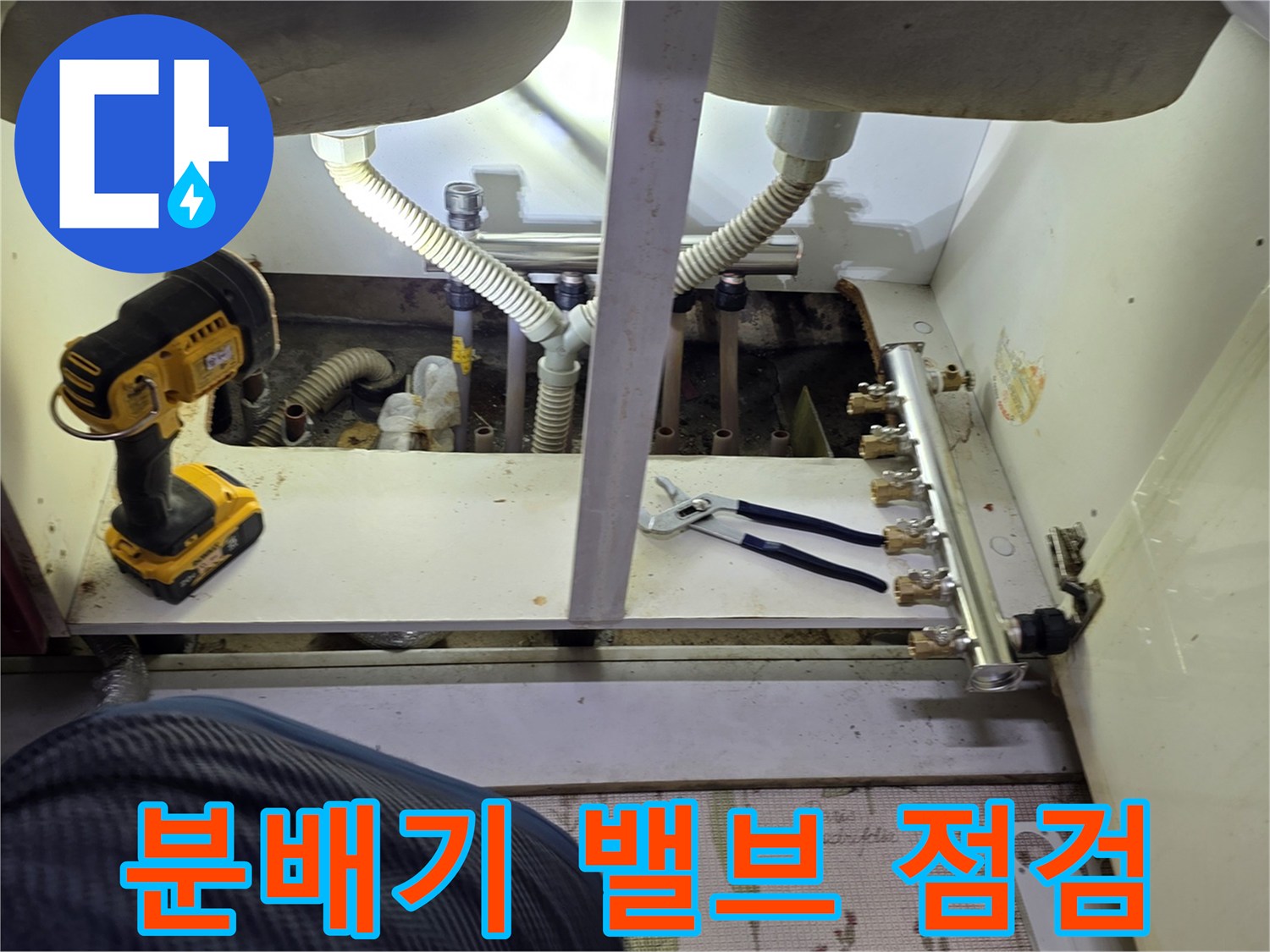 싱크대 하단-금속 분배기 밸브와 연결 배관의 상태를 체크하는 모습입니다.