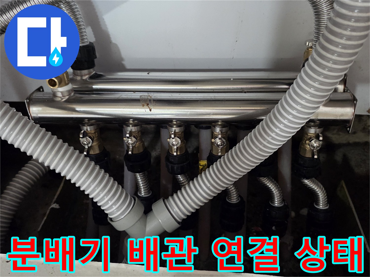 싱크대 하부 분배기와 연결된 은색 주름관의 체결 모습입니다.